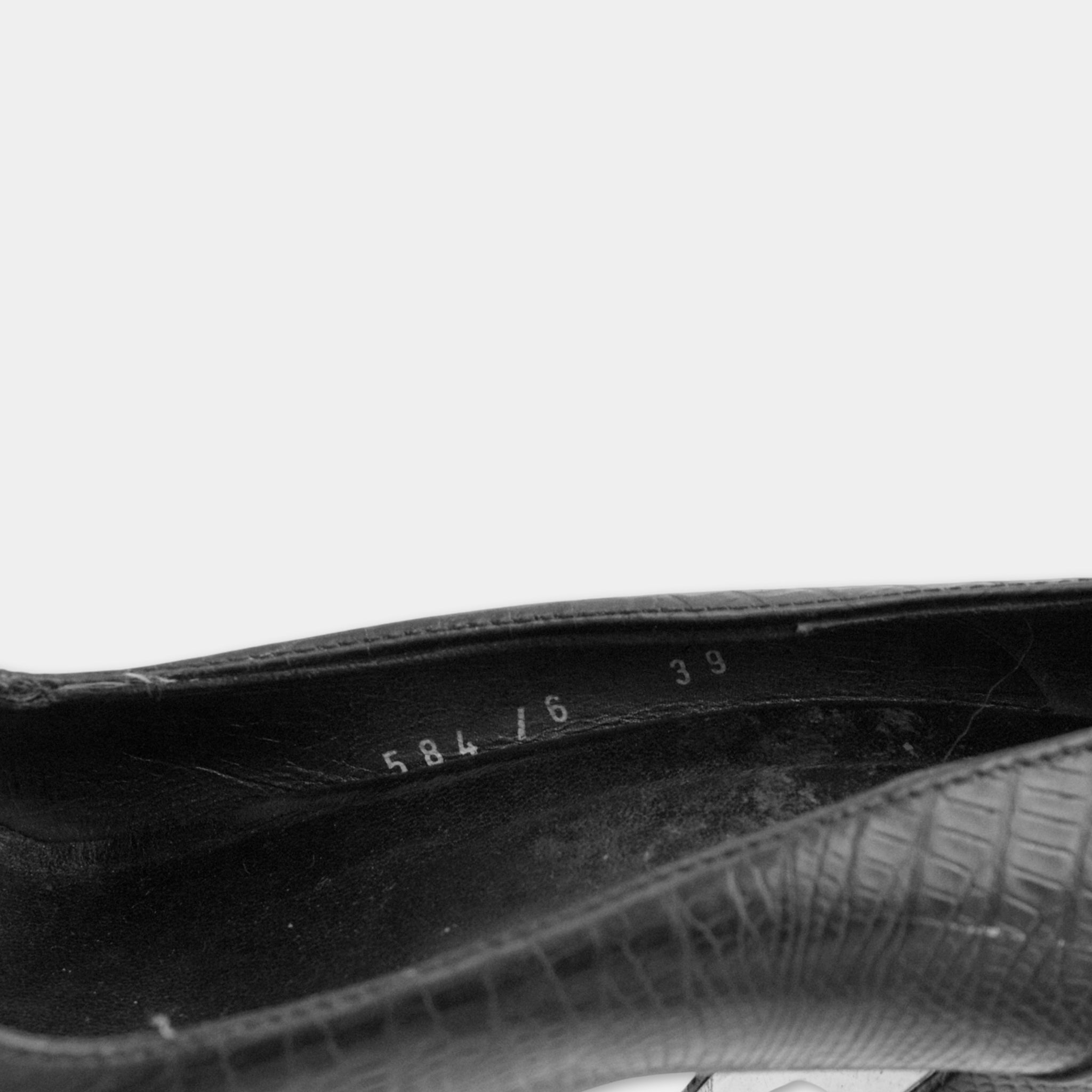 A close-up view of a black shoe, showing the sole and part of the upper part.
