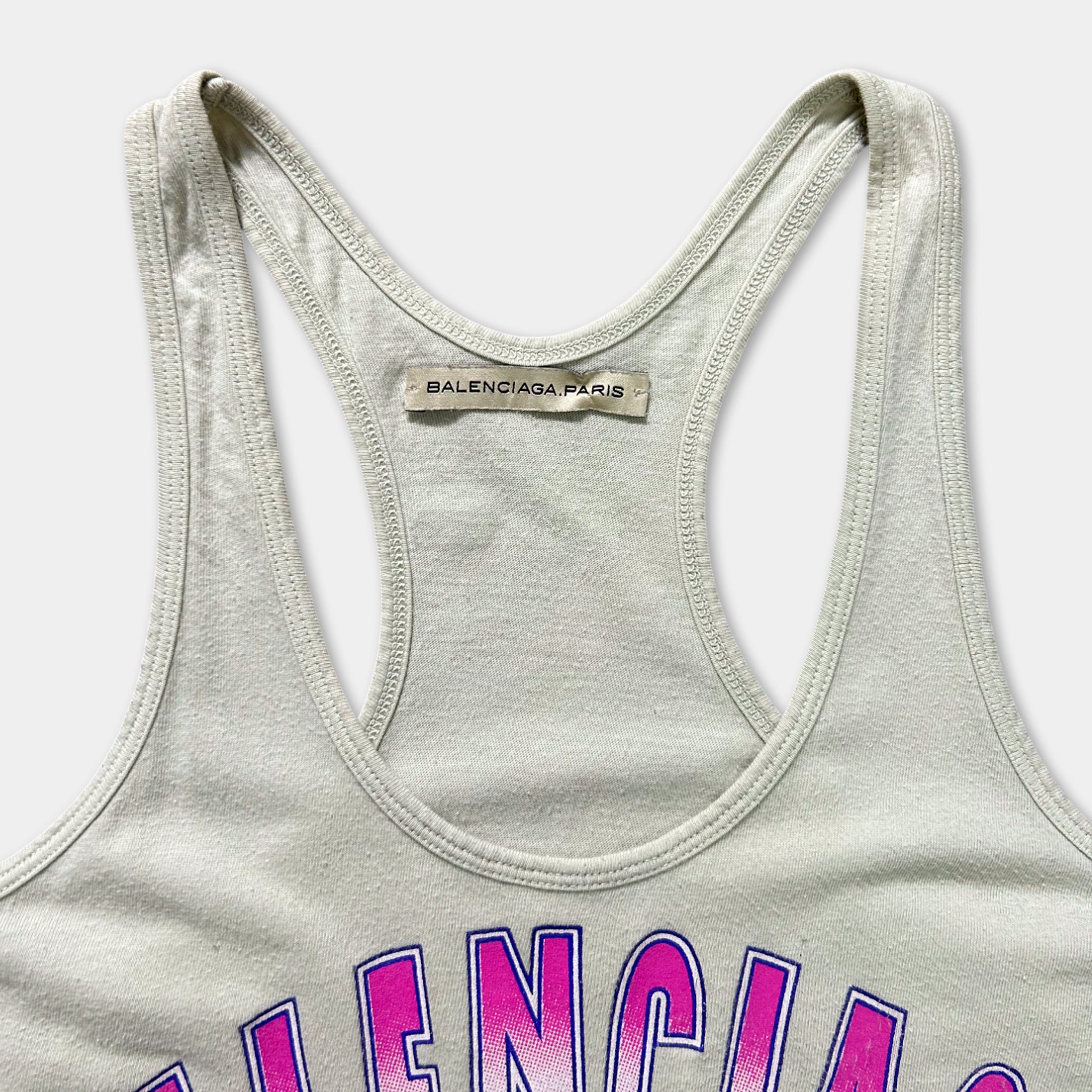 A close-up view of a grey tank top with a label that reads "BALENCIA PARIS".