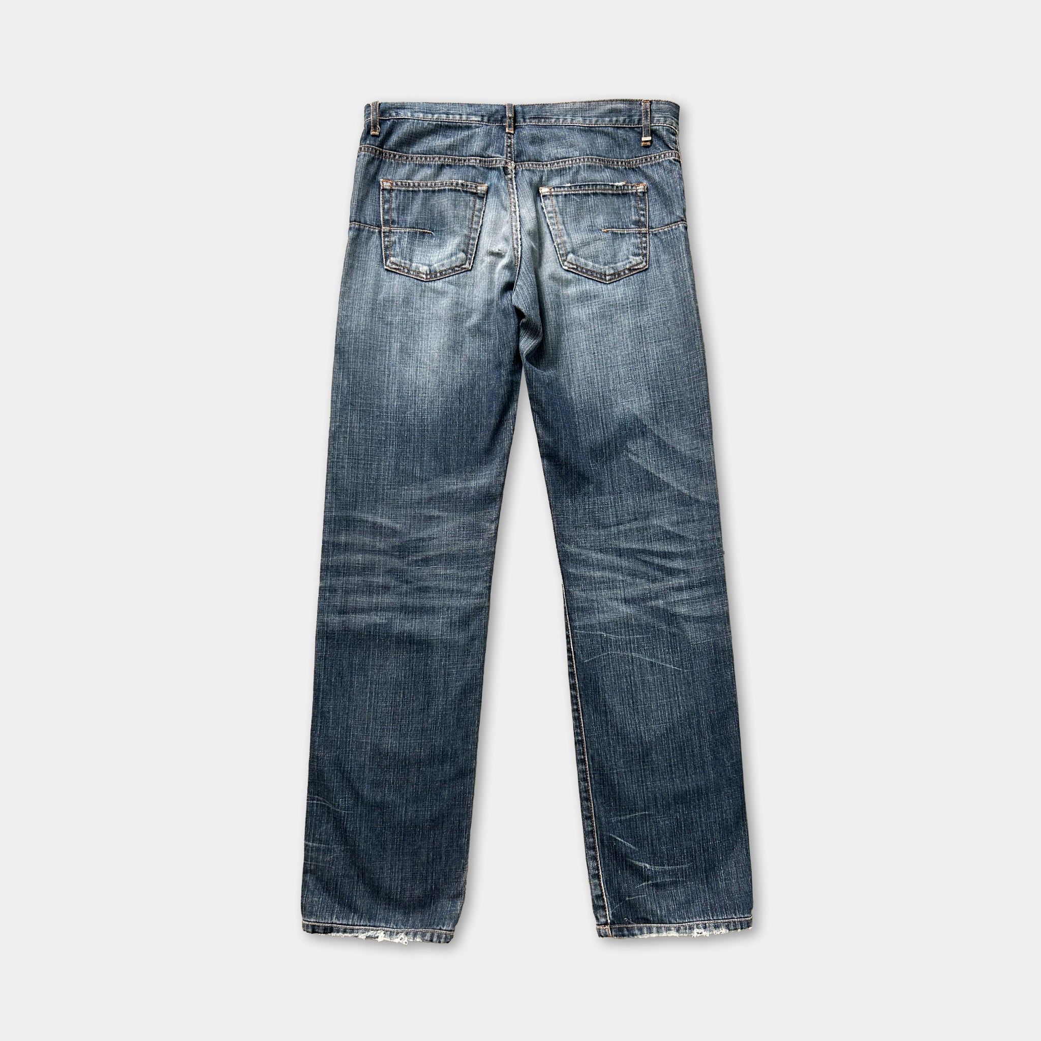 A pair of blue jeans with visible signs of wear and tear, including faded colors and creases.