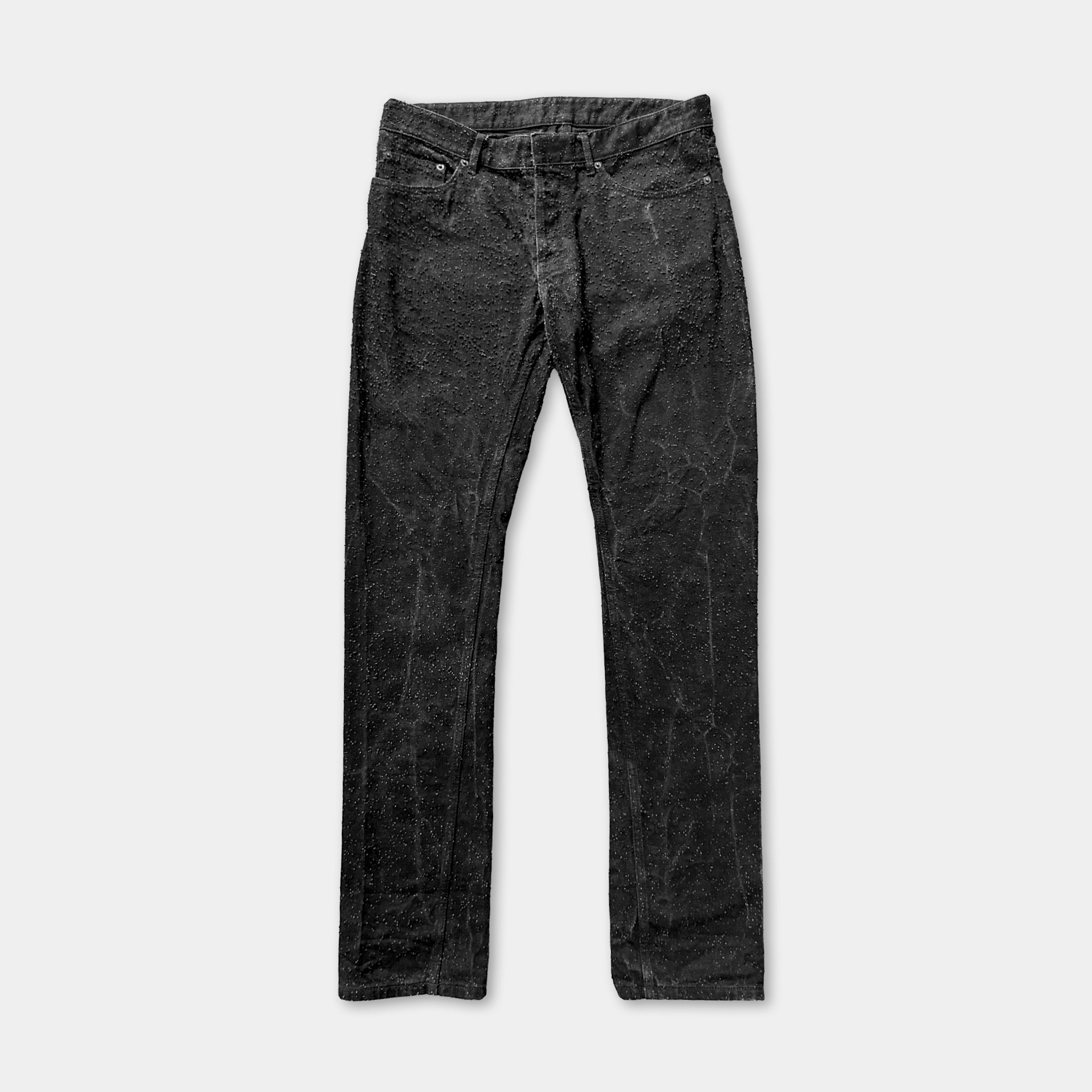 A pair of black, distressed jeans against a white background.