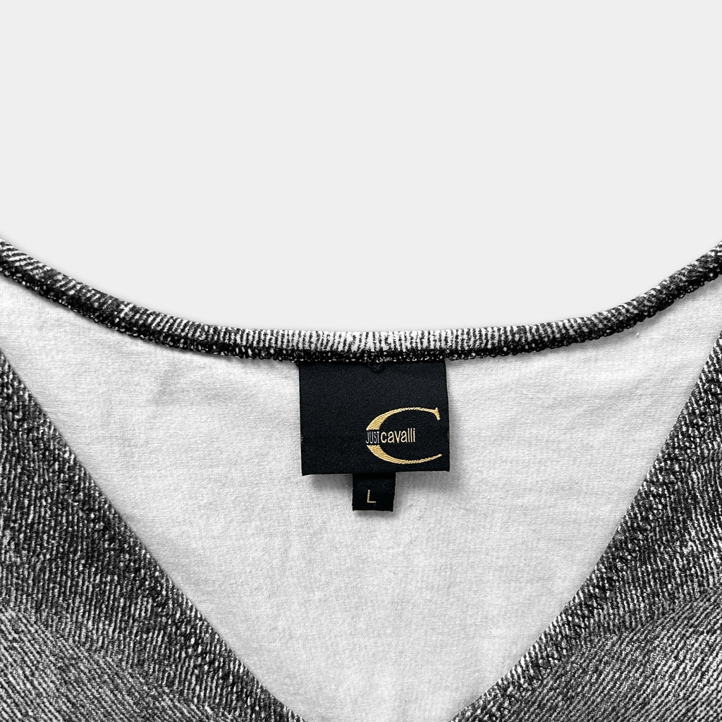 A close-up view of a black and white patterned fabric, with a label attached to the collar of the garment.