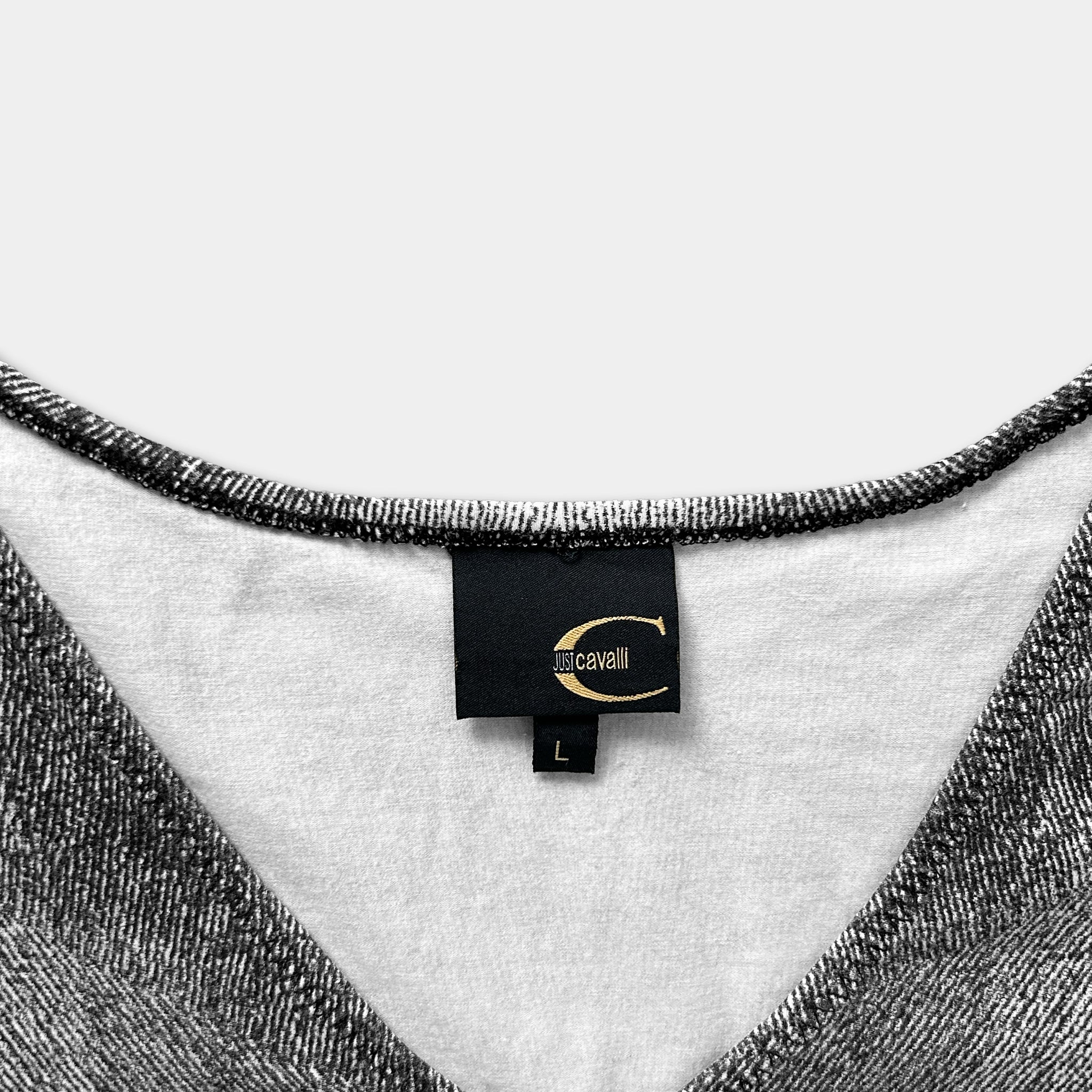 A close-up view of a black and white patterned fabric, with a label attached to the collar of the garment.
