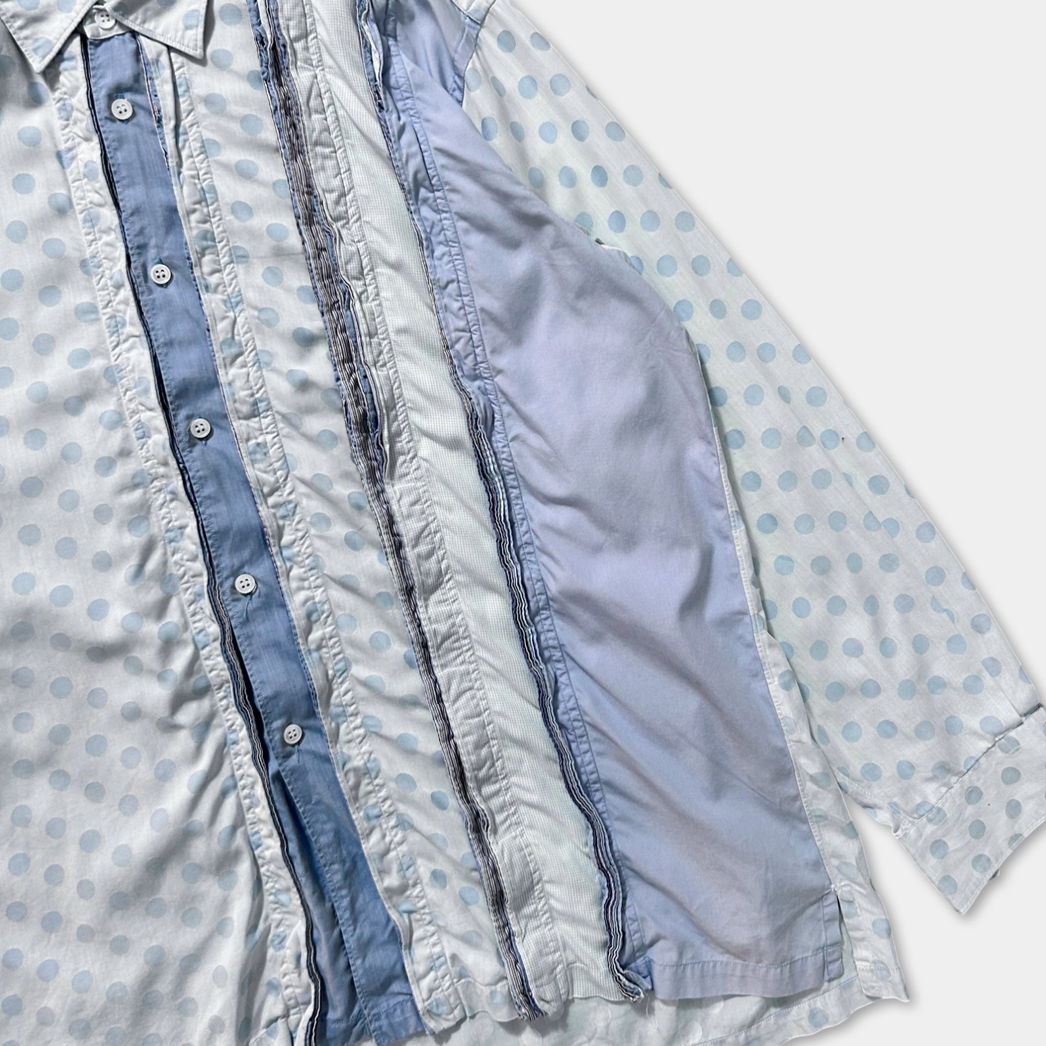 A close-up view of a collage of fabric pieces, including a blue and white polka dot shirt with a white collar and buttons.
