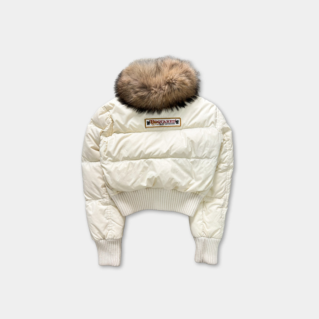 A white puffy jacket with a fur collar and a patch on the back.