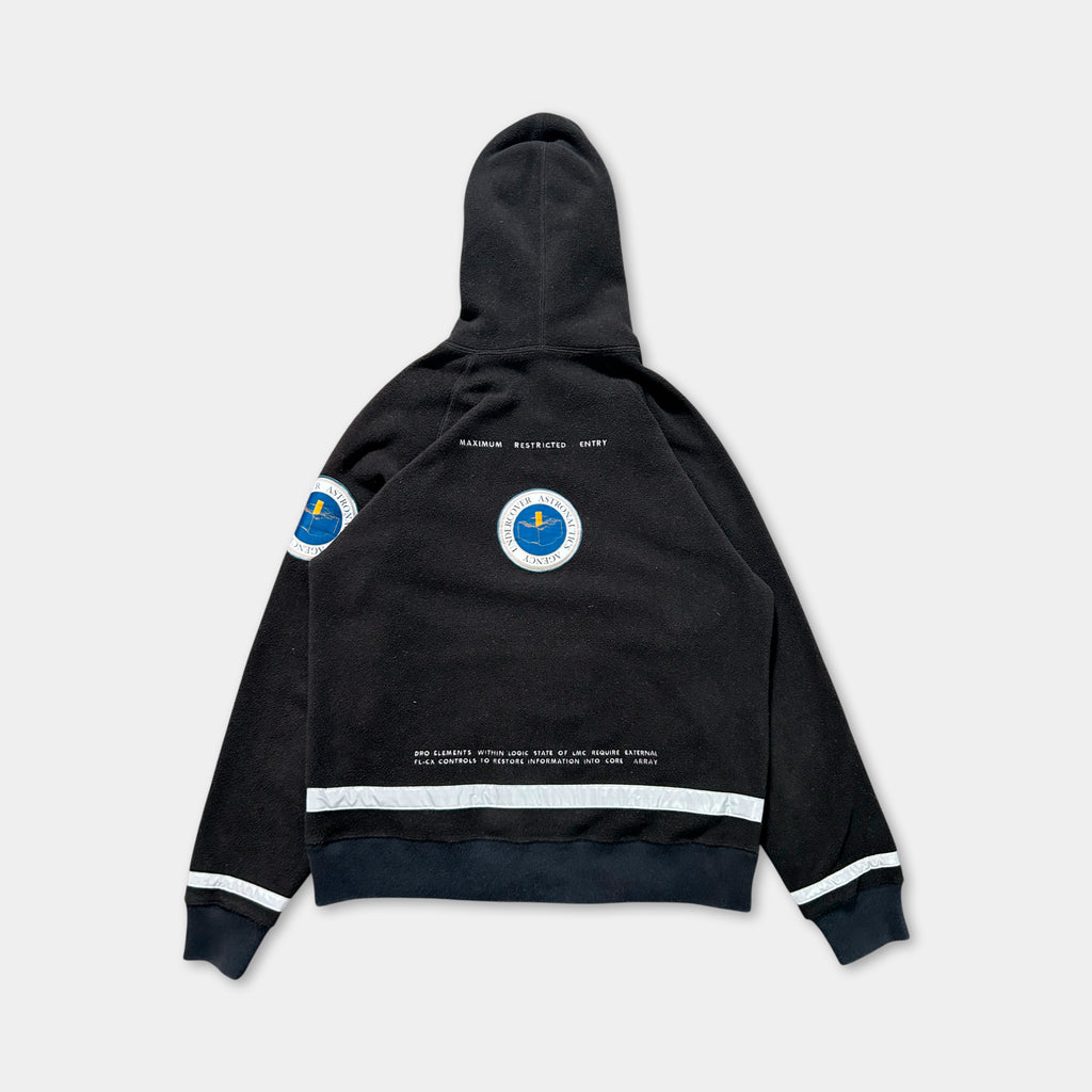 a black hooded sweatshirt with a circular logo on the back.