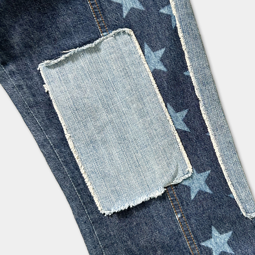 A close-up view of a pair of blue jeans with a patchwork design featuring blue stars on the fabric.