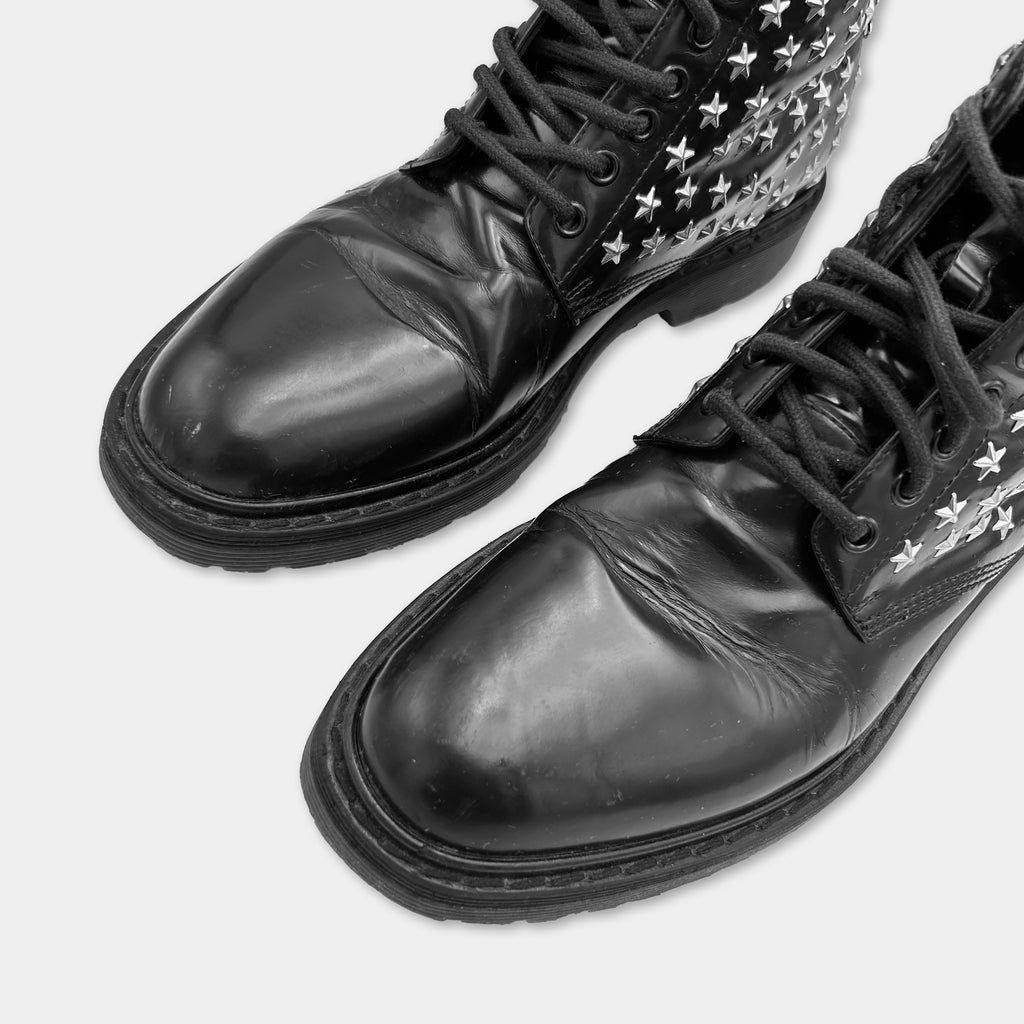 A pair of black leather boots with star-patterned laces and soles.
