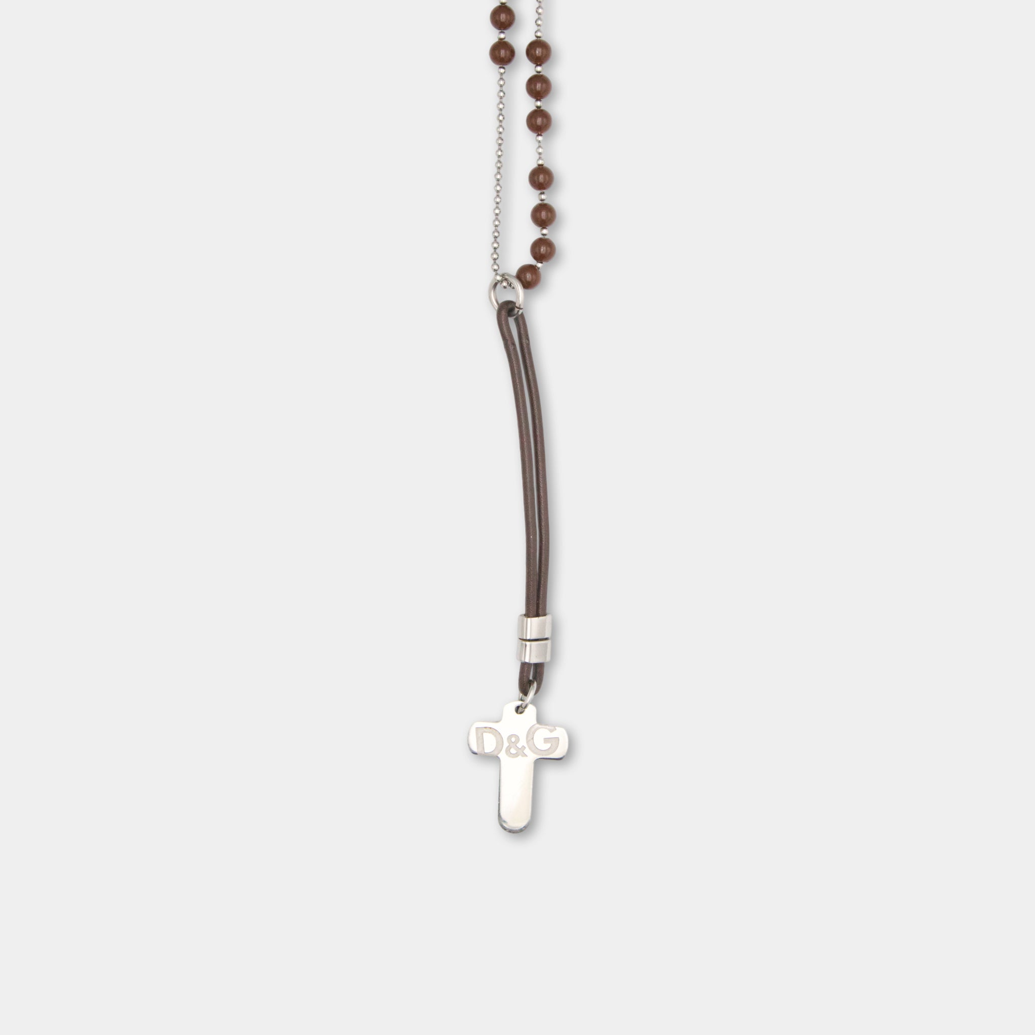 A necklace with a cross pendant and brown beads hanging from it.