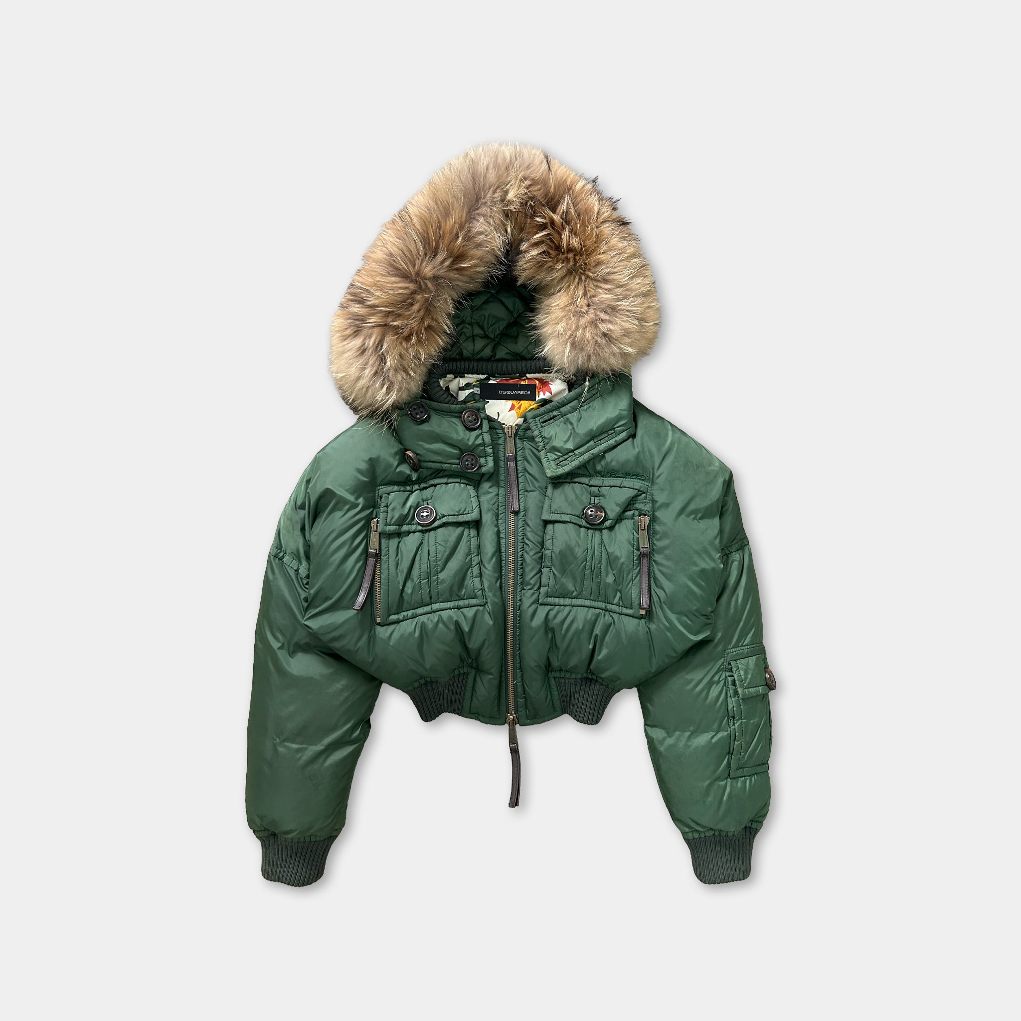 A green puffy jacket with a fur-trimmed hood, featuring multiple pockets and zippers.