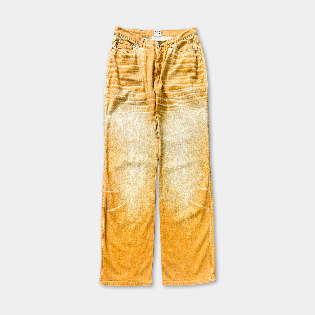 A pair of yellow-orange jeans with a distressed, worn appearance.