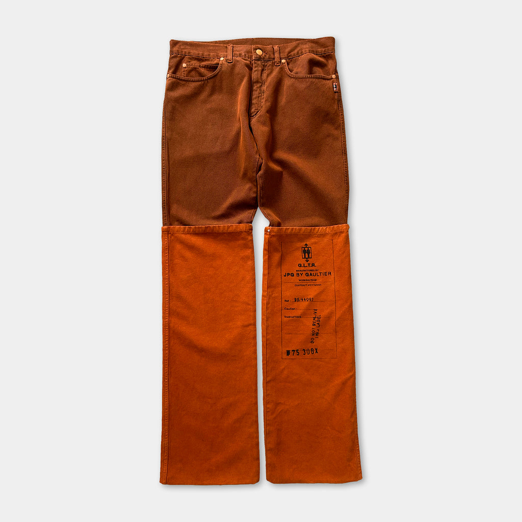 A pair of brown jeans with an orange sleeve attached to the front.