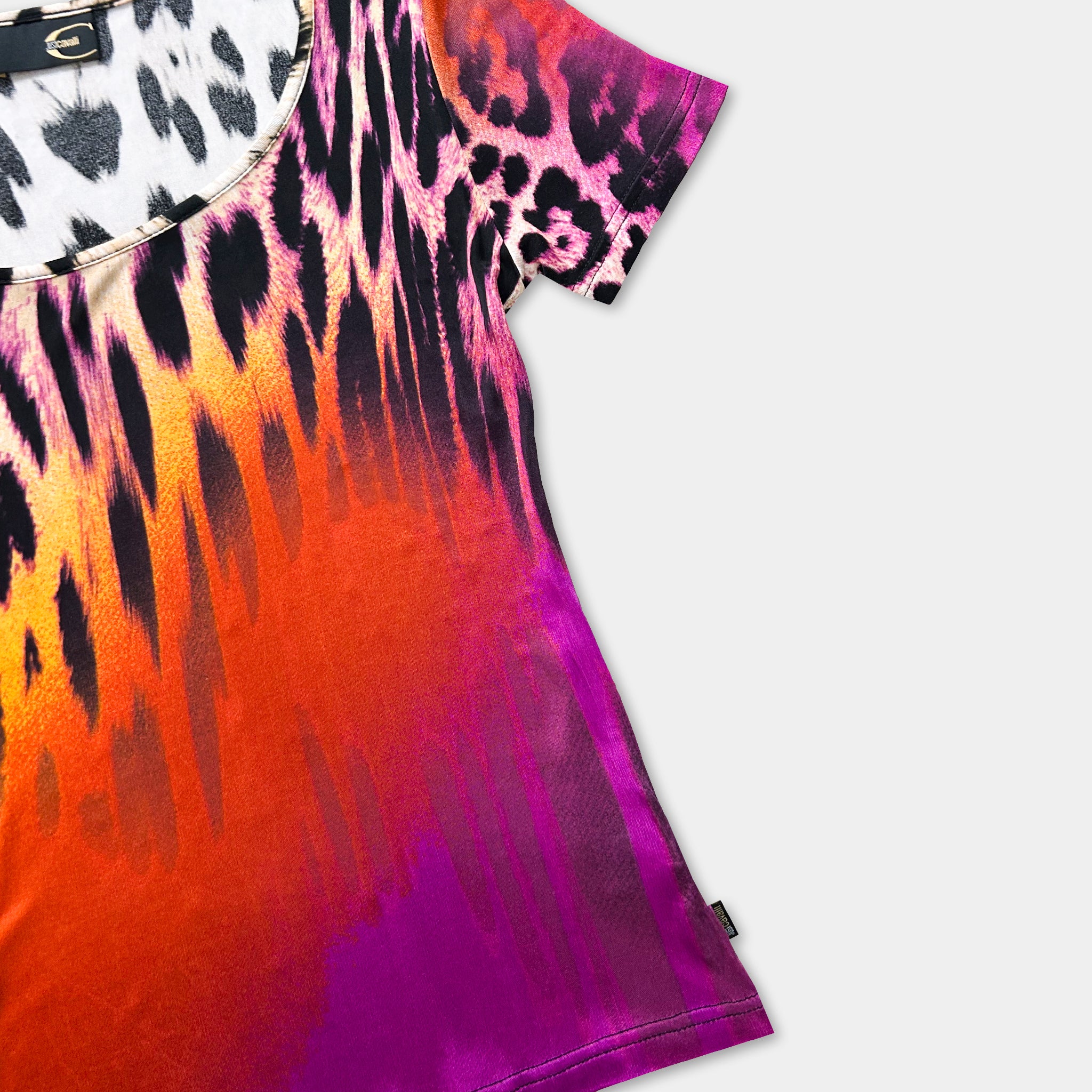 A colorful, patterned t-shirt with a vibrant mix of orange, pink, and black colors.