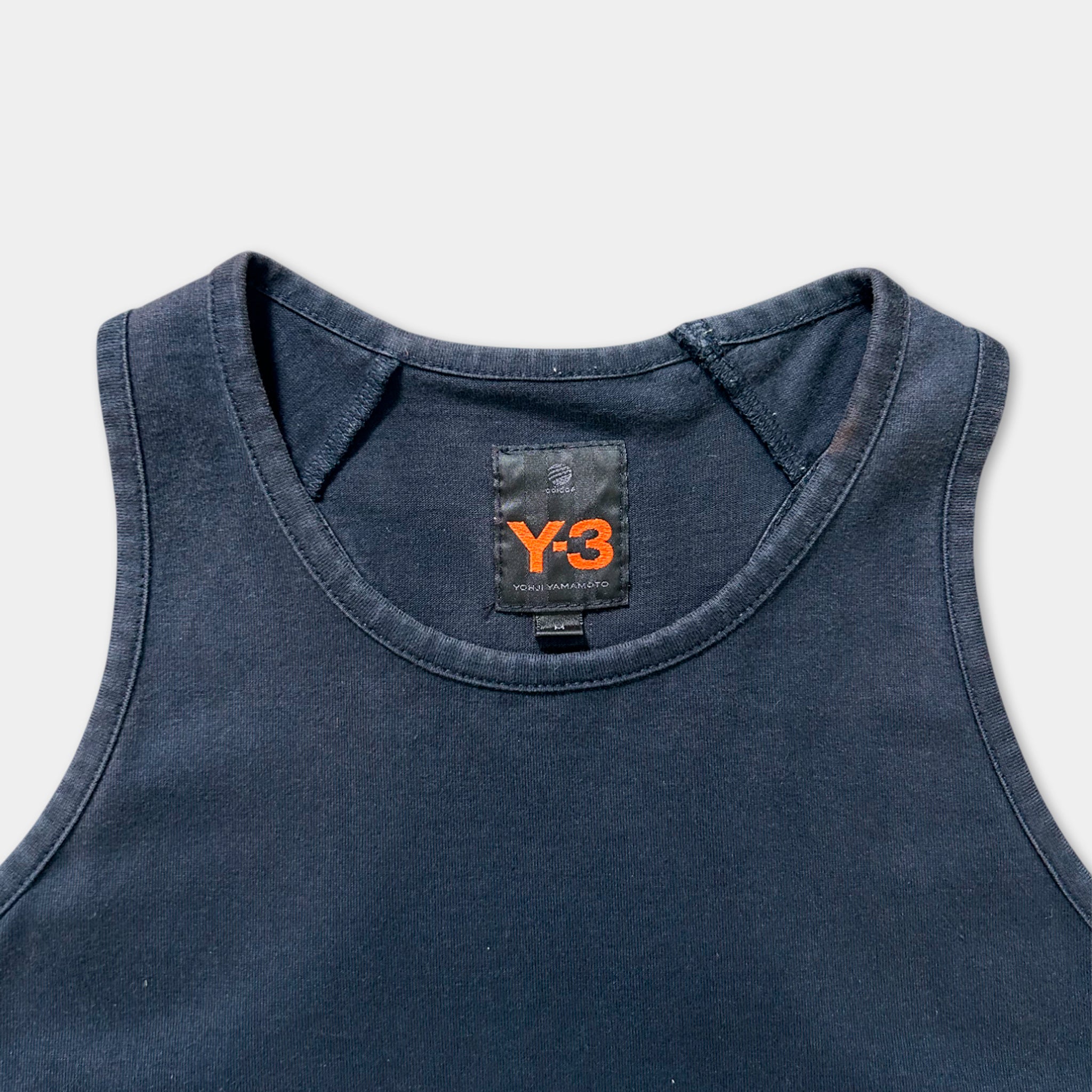 A dark blue tank top with a black label on the collar.