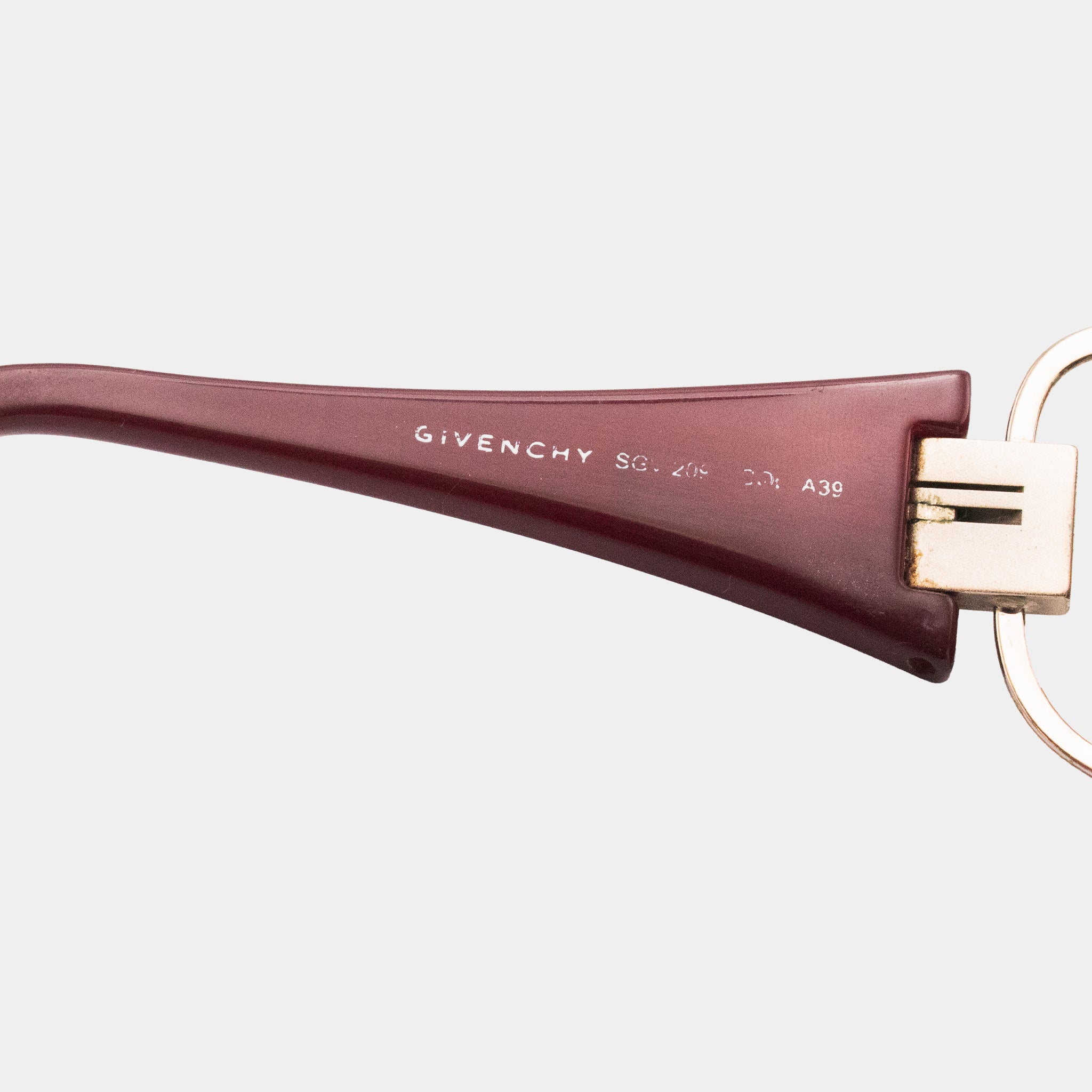 A close-up view of a burgundy-colored frame with the brand name "GIVENCHY" printed on it.
