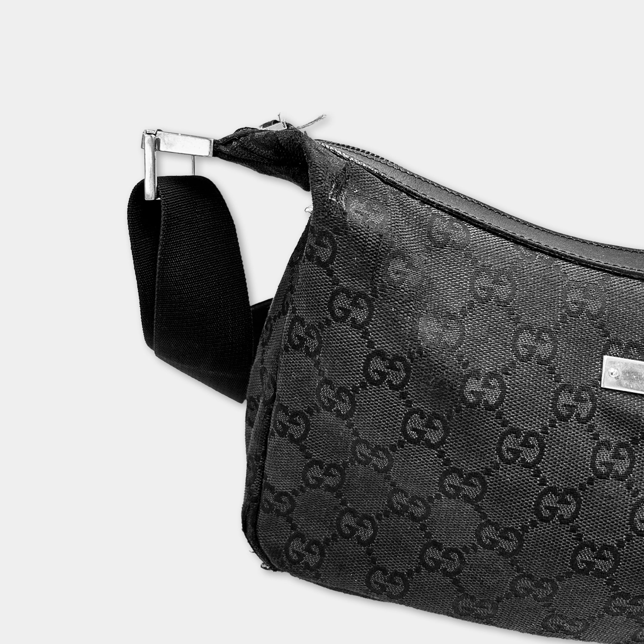 A black Gucci handbag with a distinctive monogram pattern.