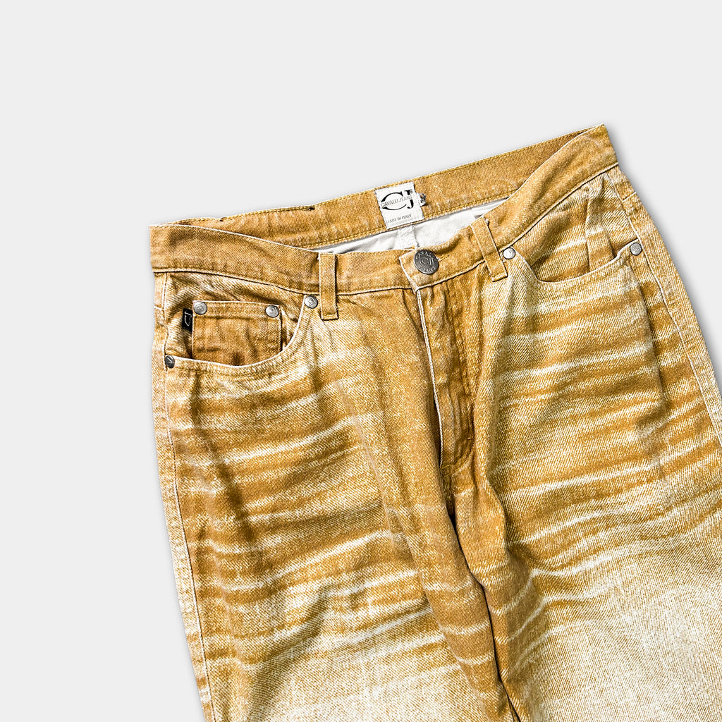 A pair of tan-colored jeans with a distinctive pattern, displayed against a plain white background.