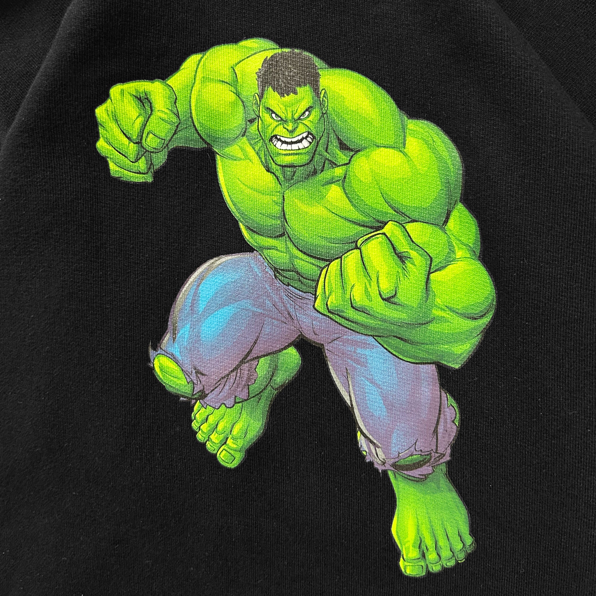 A muscular, green-skinned character with a determined expression is depicted in a dynamic fighting pose against a black background.