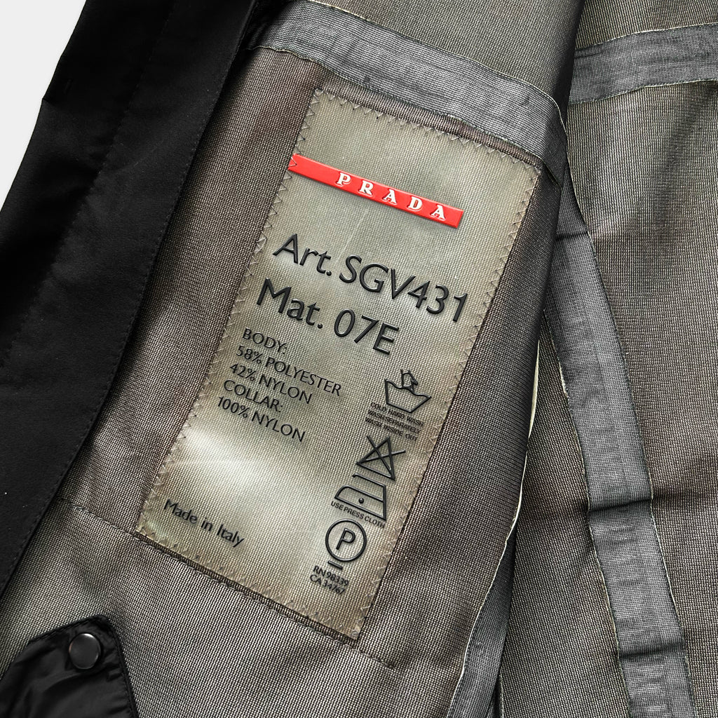 a close-up view of a Prada jacket, focusing on the label that provides information about the jacket's material and manufacturing origin.