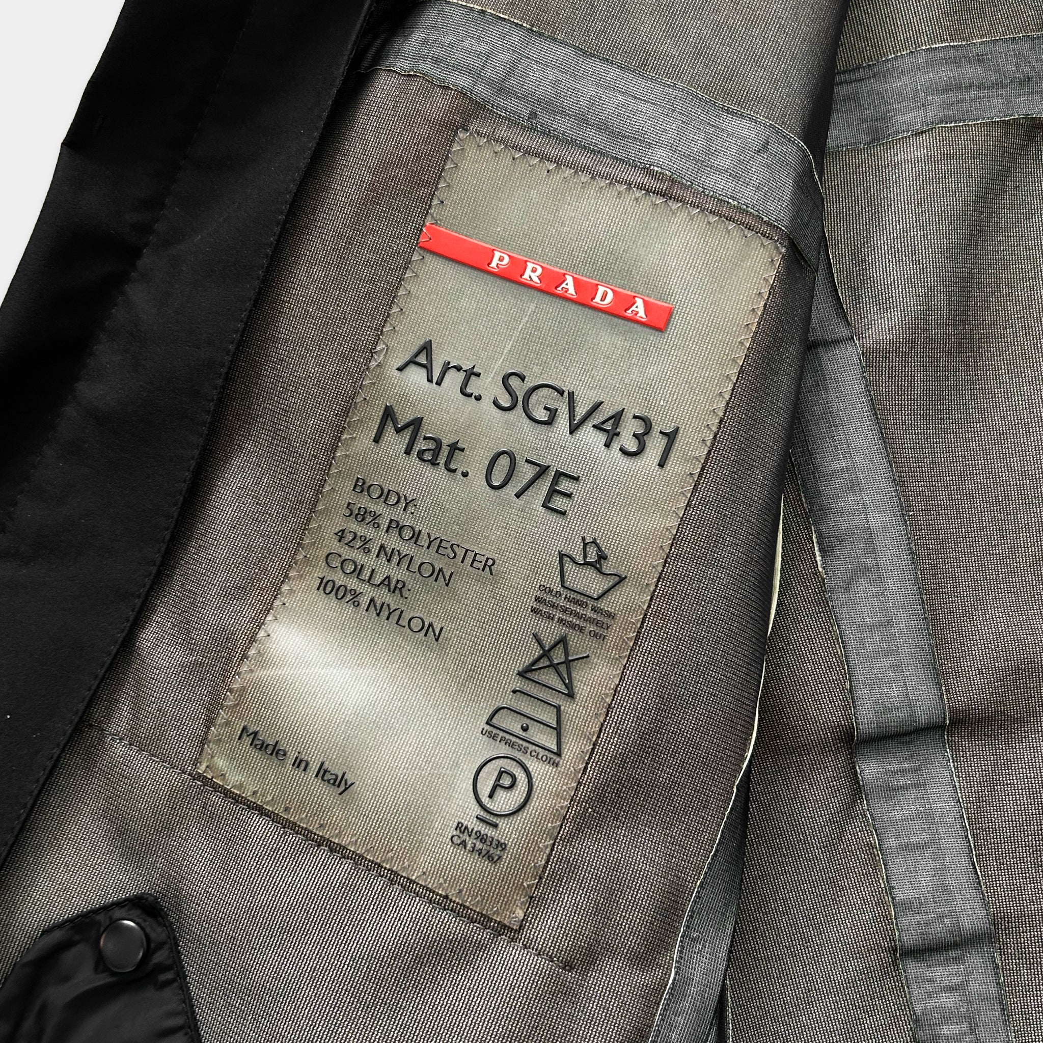 a close-up view of a Prada jacket, focusing on the label that provides information about the jacket's material and manufacturing origin.