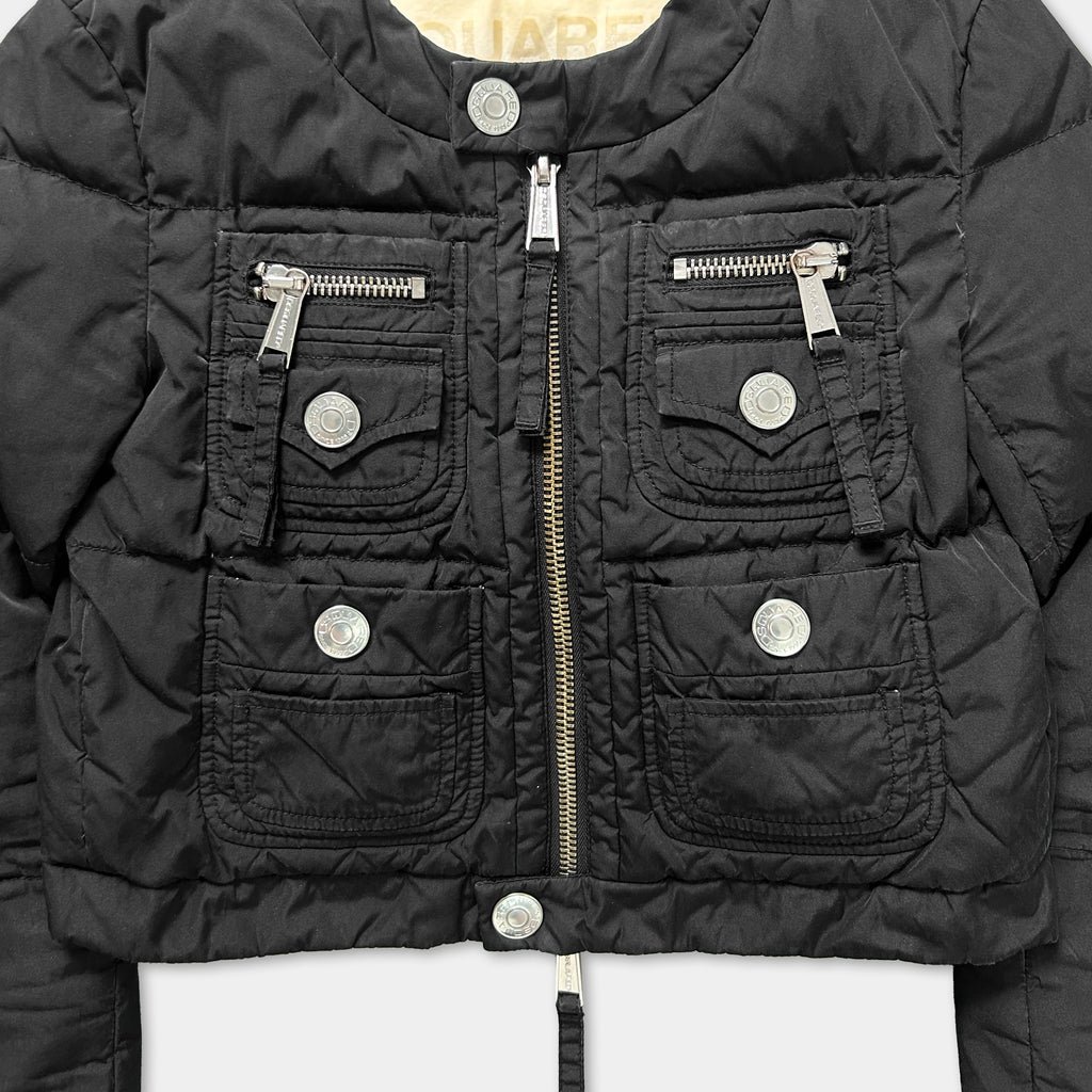 A close-up view of a black jacket with multiple pockets and zippers.