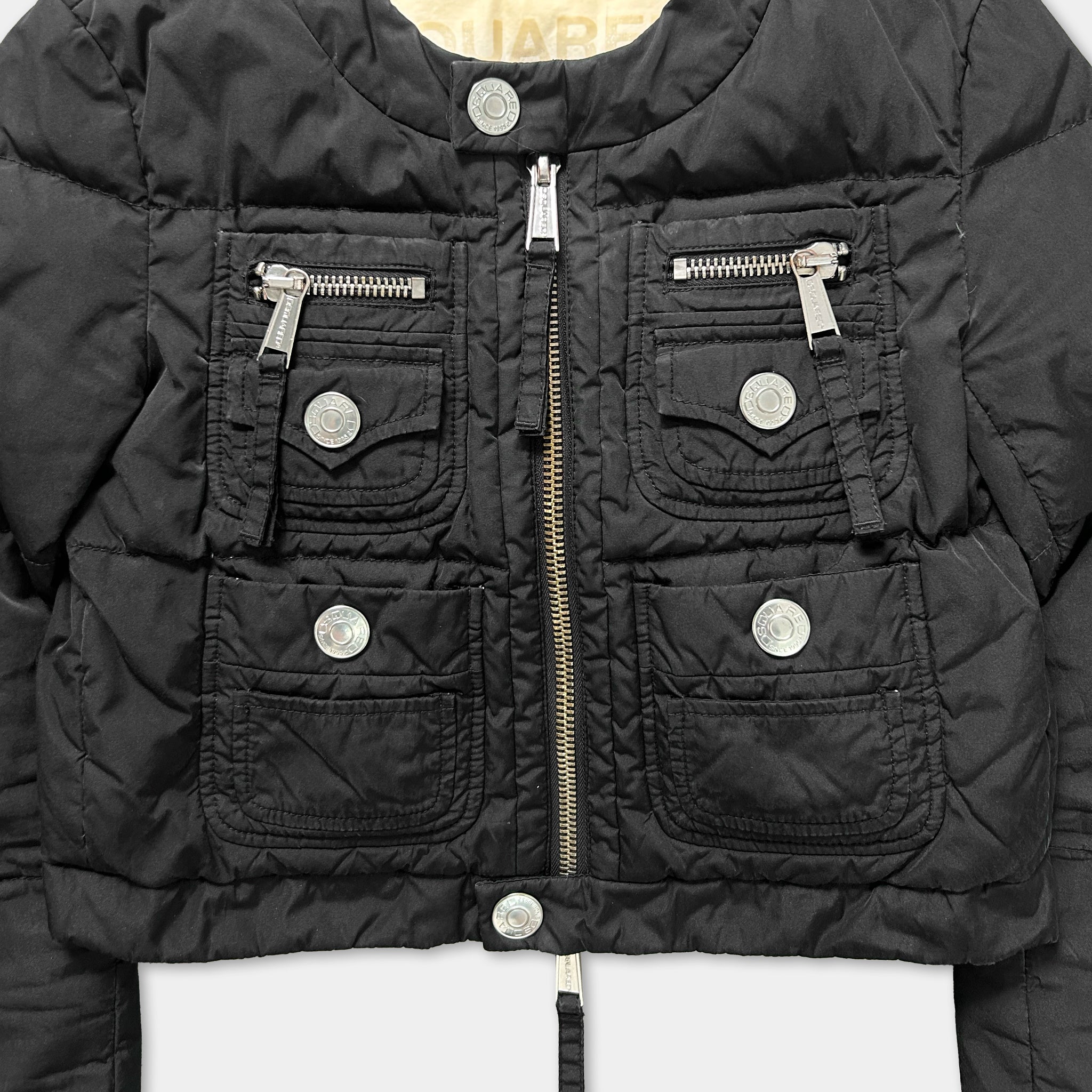 A close-up view of a black jacket with multiple pockets and zippers.