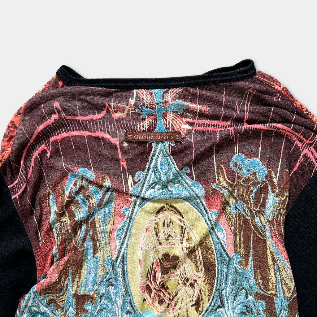 a colorful, patterned shirt with a religious design featuring a cross and various figures.