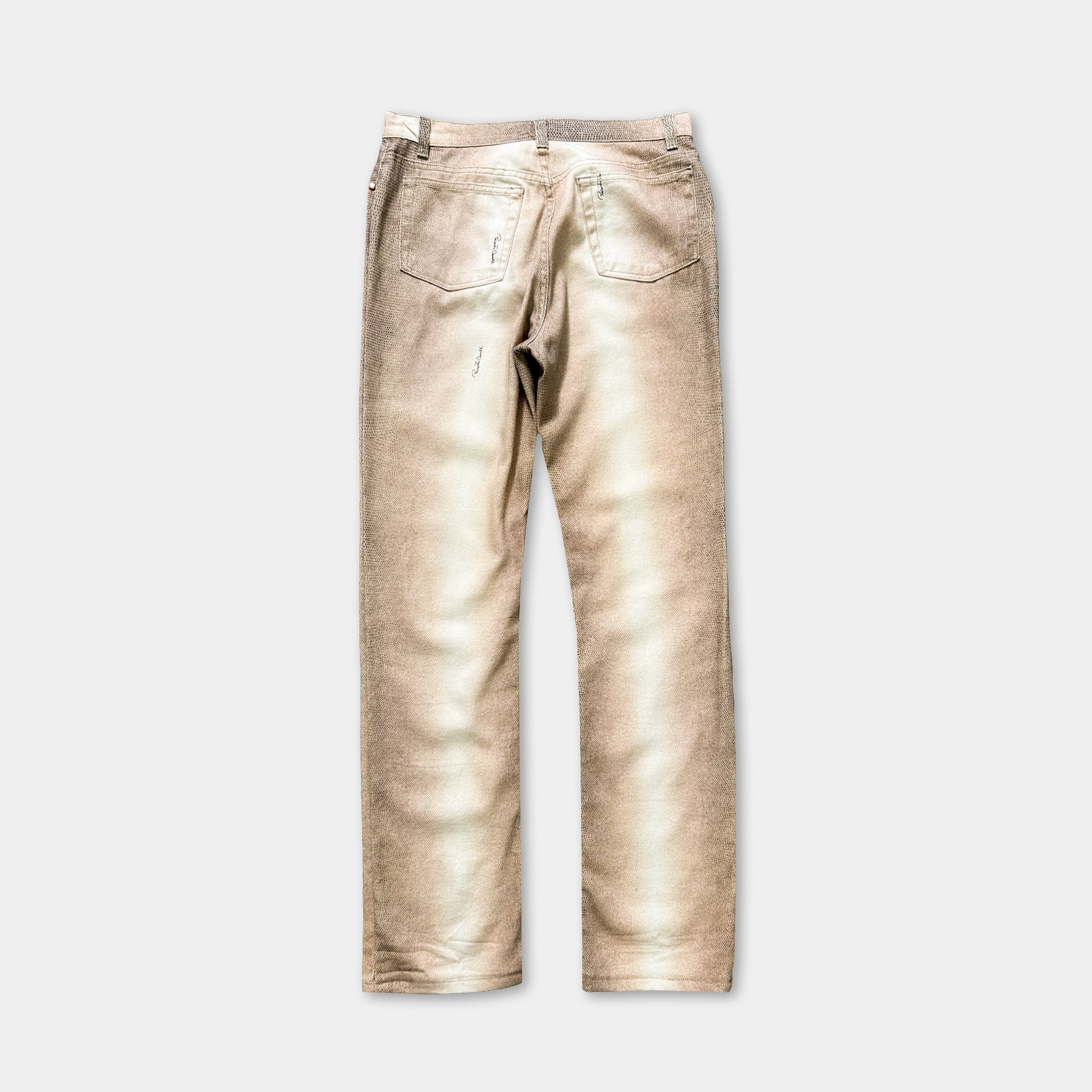 A pair of tan-colored jeans with visible wear and tear, including a small tear in the pocket and frayed edges on the knees.