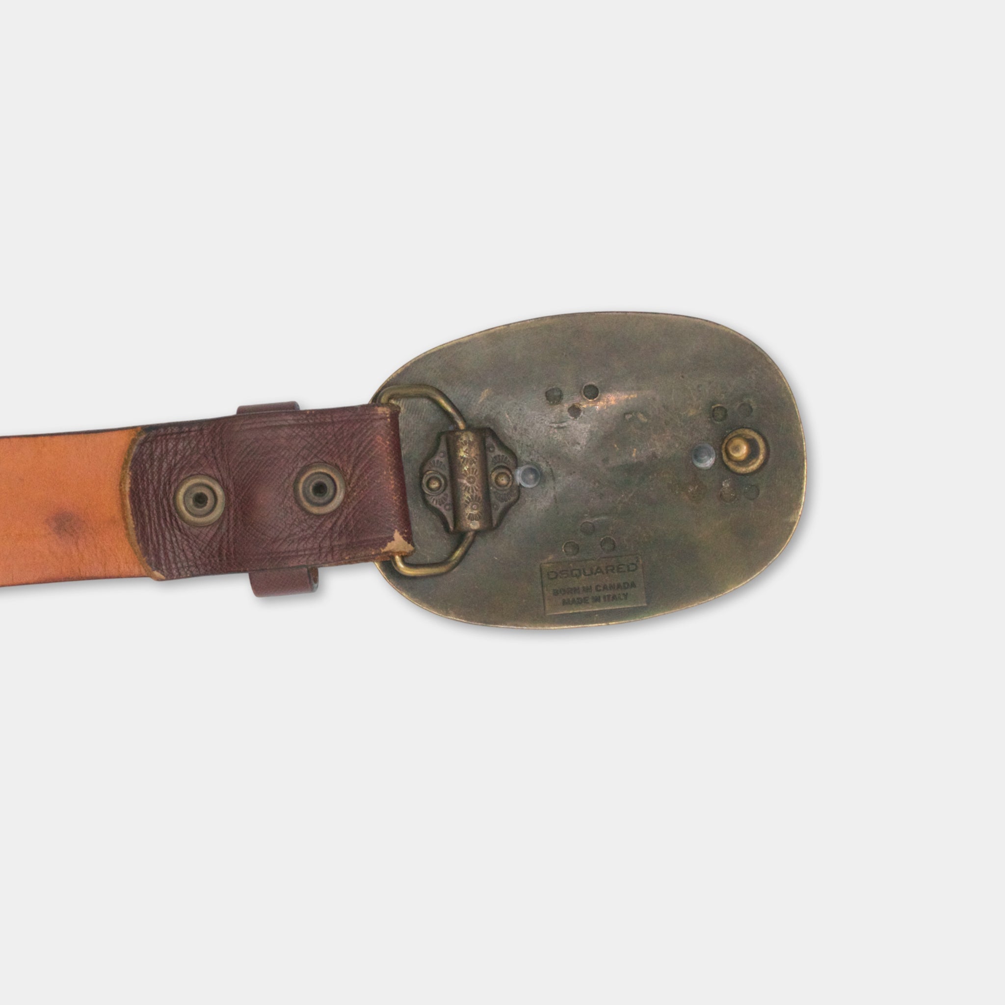 A brown leather belt with a metal buckle and a metal plate with text on it.