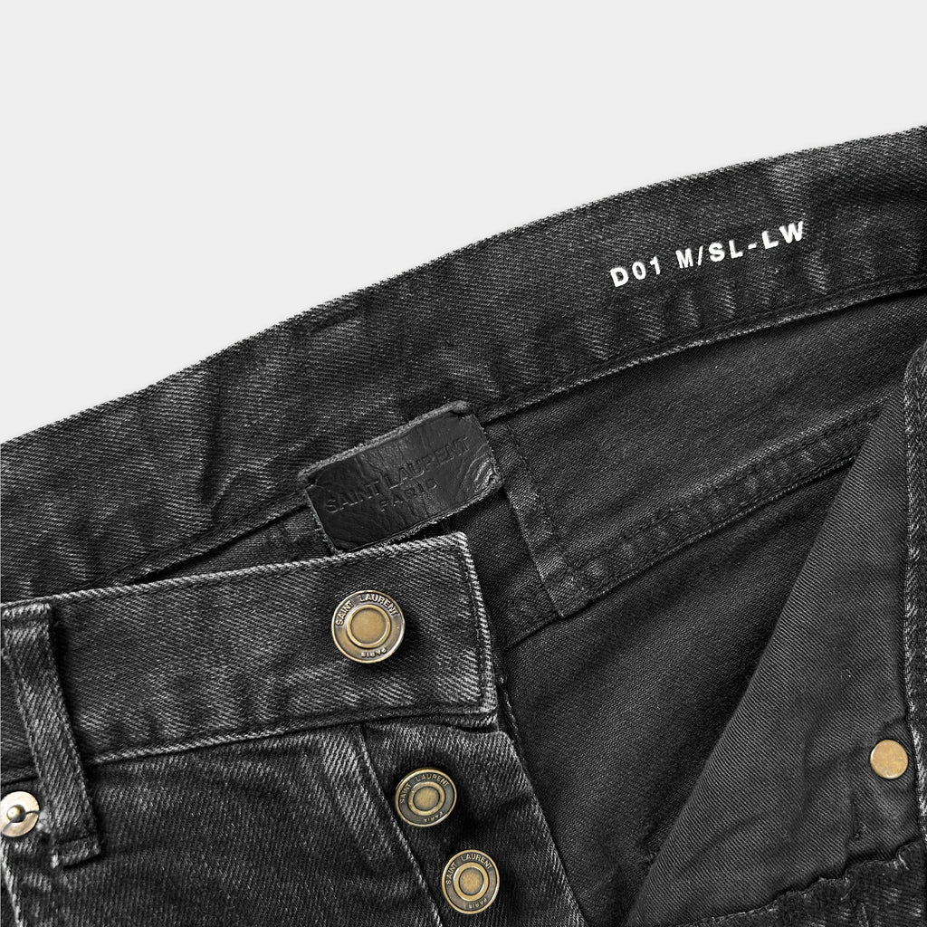 a close-up view of a pair of black jeans with a label on the waistband.