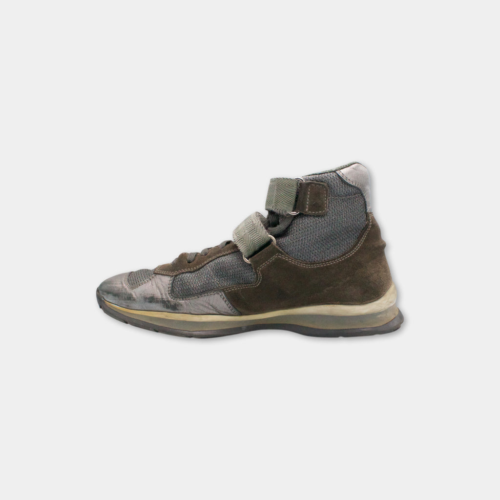 A worn and dirty high-top sneaker with a mesh upper and a brown leather upper, showing signs of use and age.