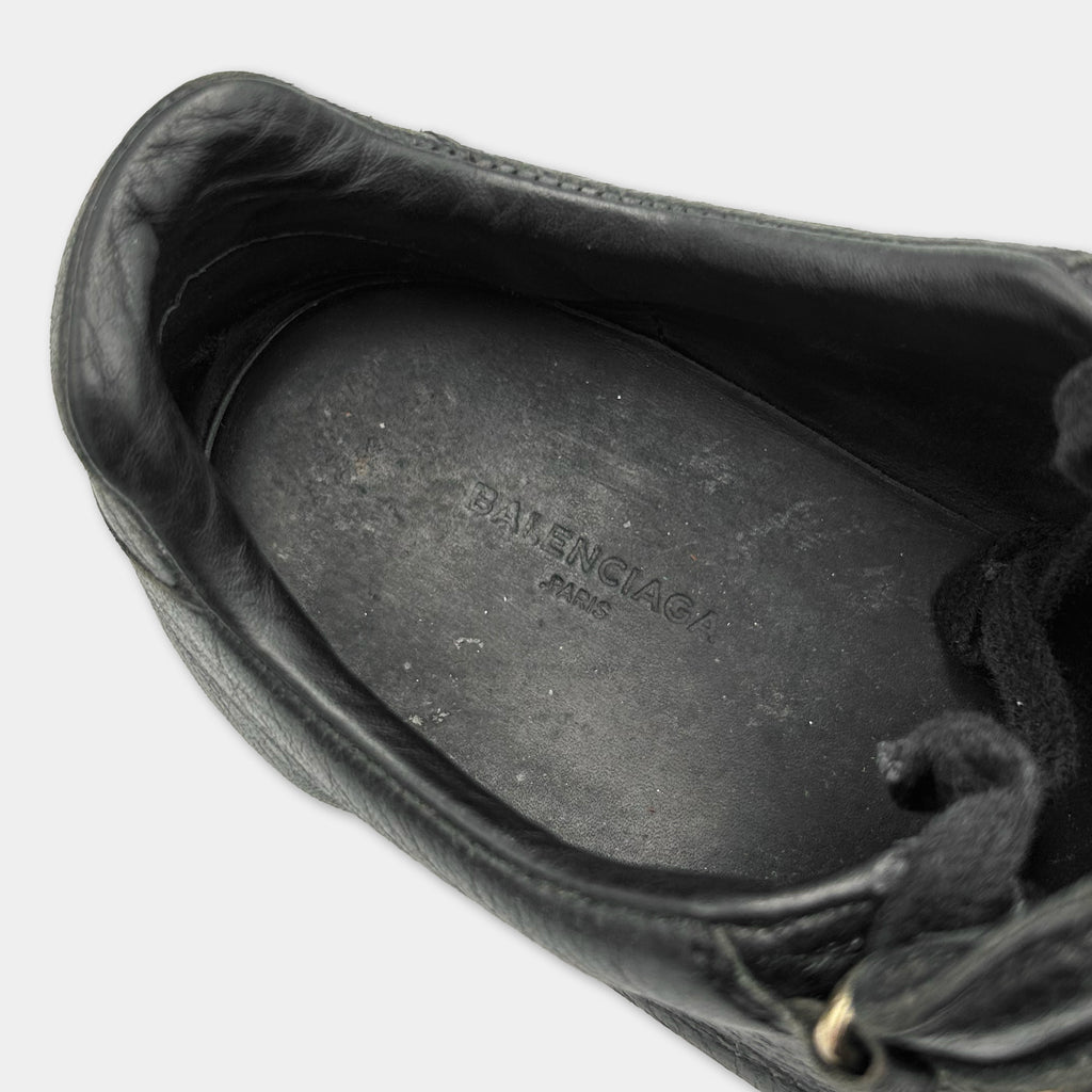 A close-up view of a black leather shoe sole with the Balenciaga logo printed on it.