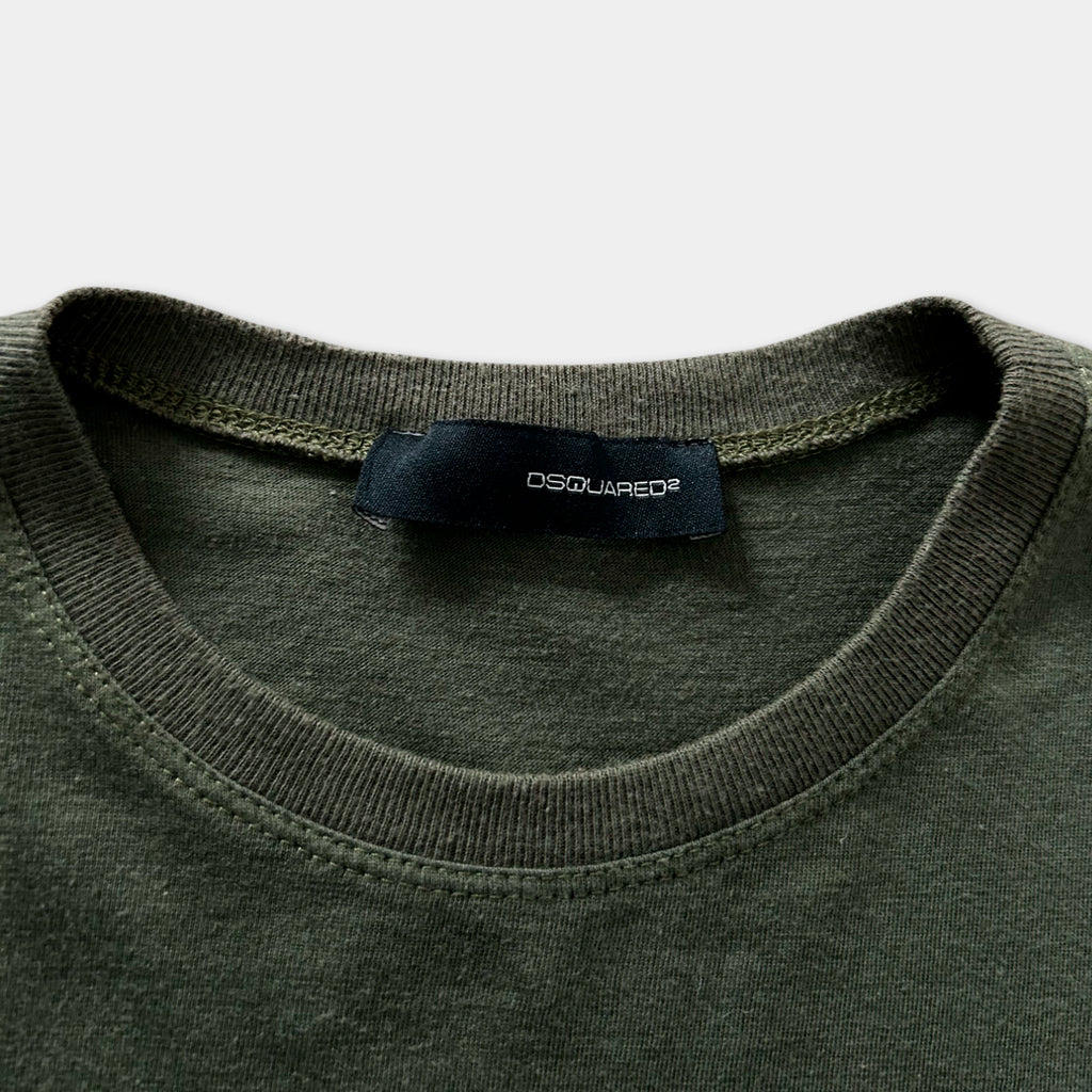 A close-up view of a dark green t-shirt with a black label that reads "DSQUARED".