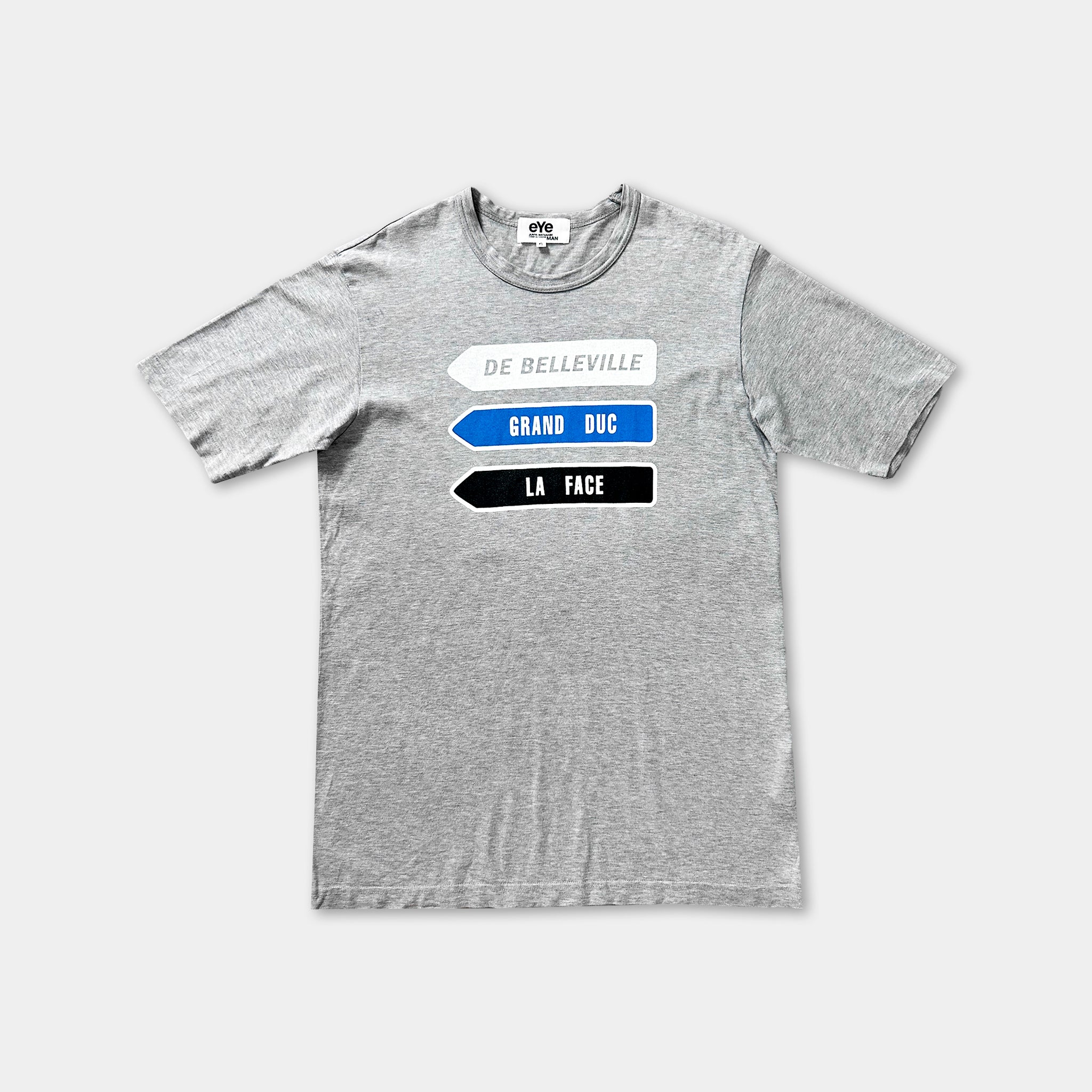 A gray t-shirt with a graphic design featuring three arrows pointing in different directions, each labeled with a different word.