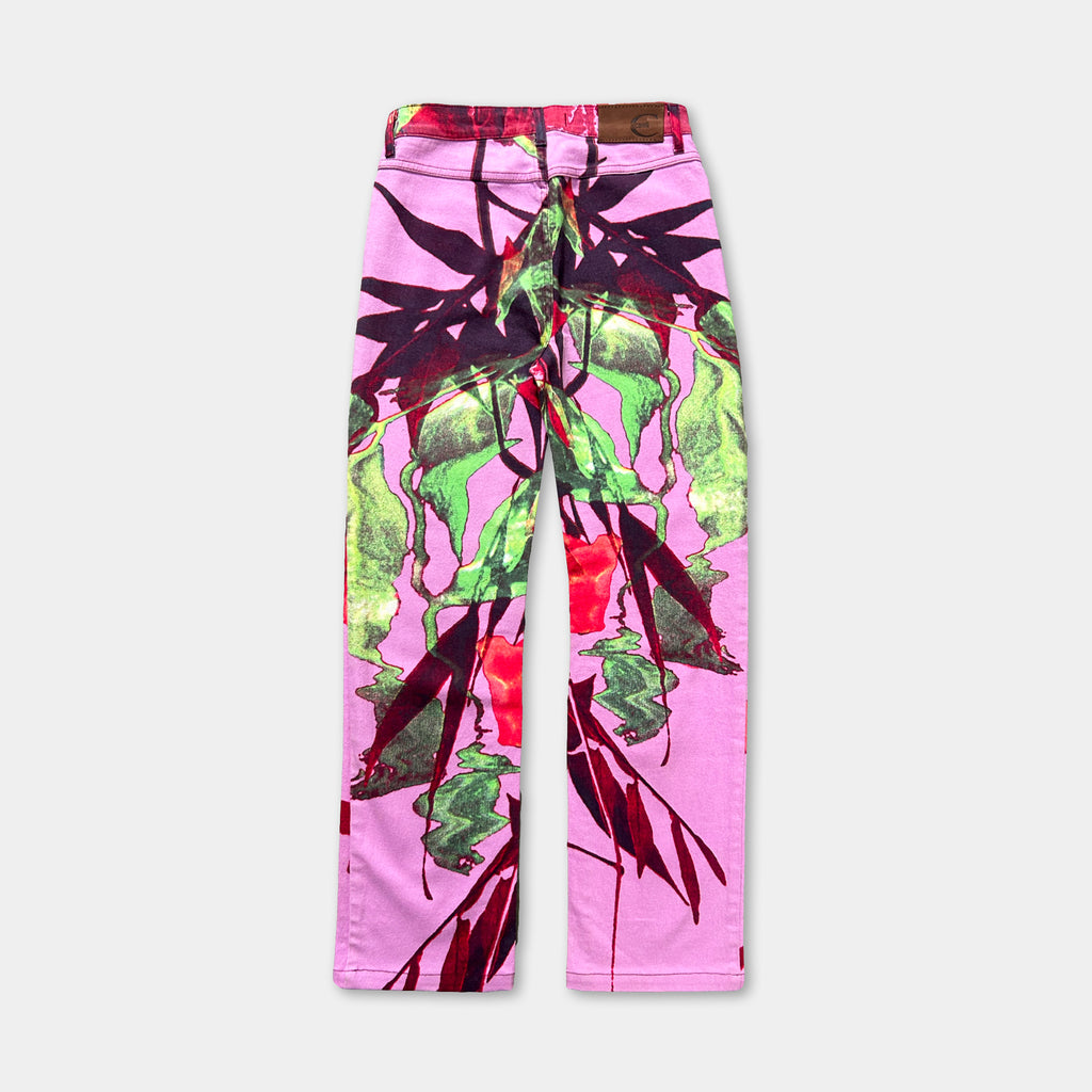 A pair of pink jeans with a vibrant, abstract floral pattern printed on them.