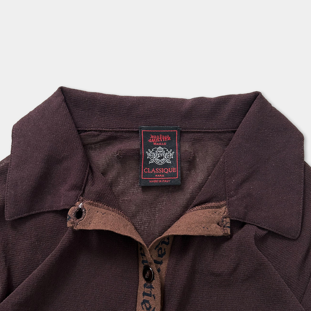 A close-up view of a brown collared shirt with a label on the collar.