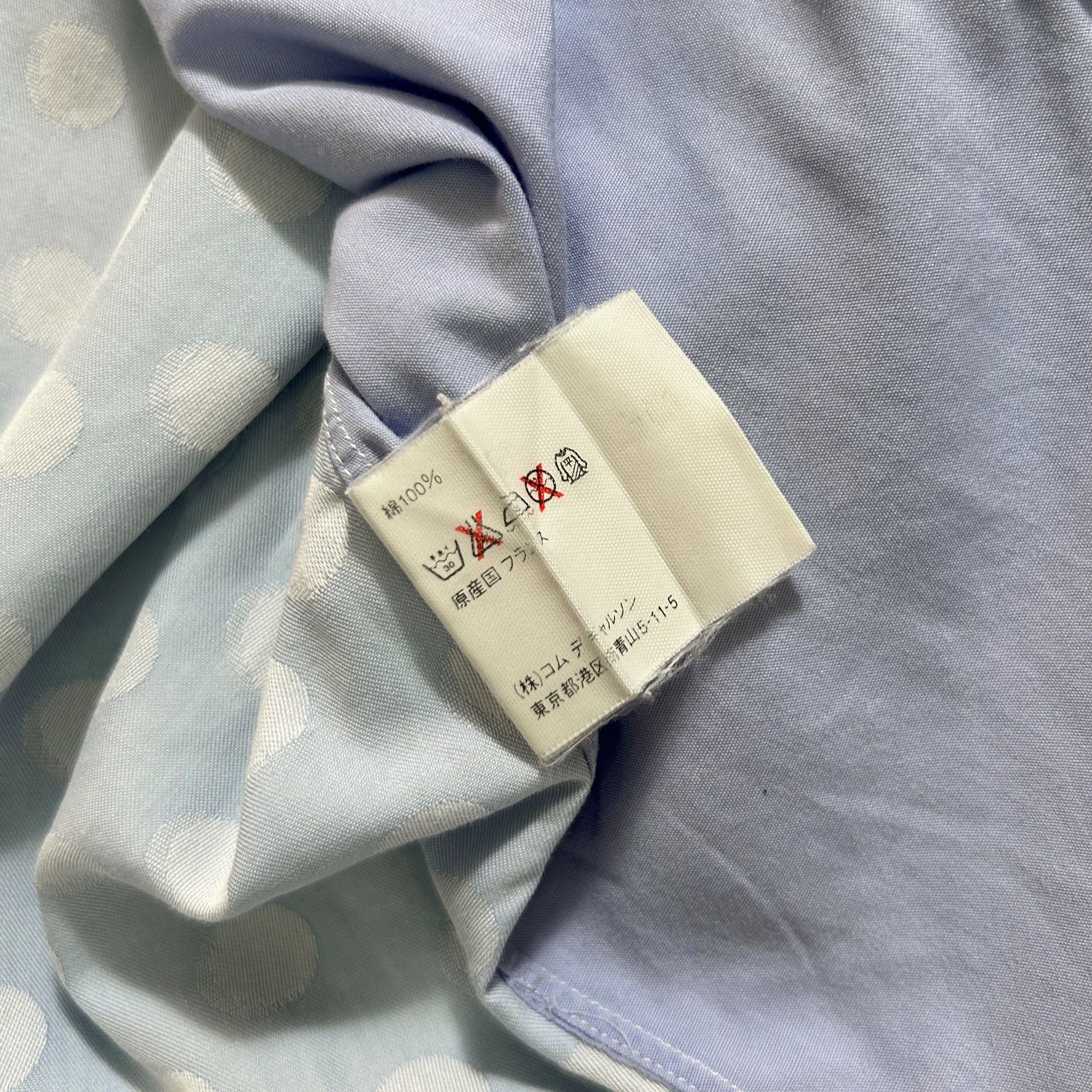 a close-up view of a fabric with a white label attached to it, which has some text and symbols on it.