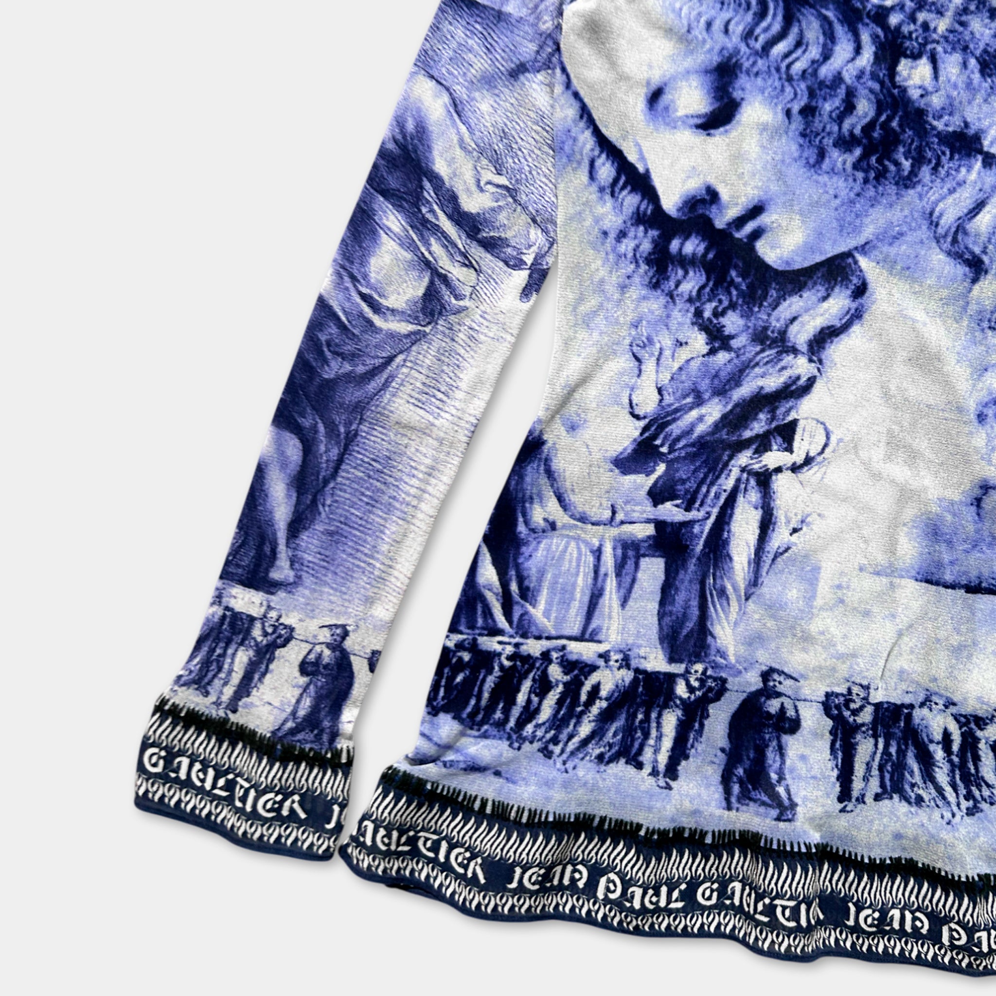 a long-sleeved shirt with a blue and white printed design depicting a woman's face and a group of people.