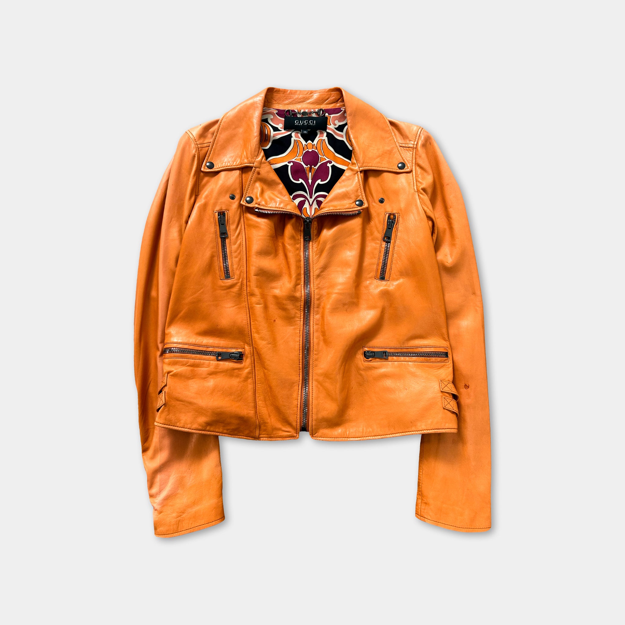 An orange leather jacket with a floral pattern on the chest area.