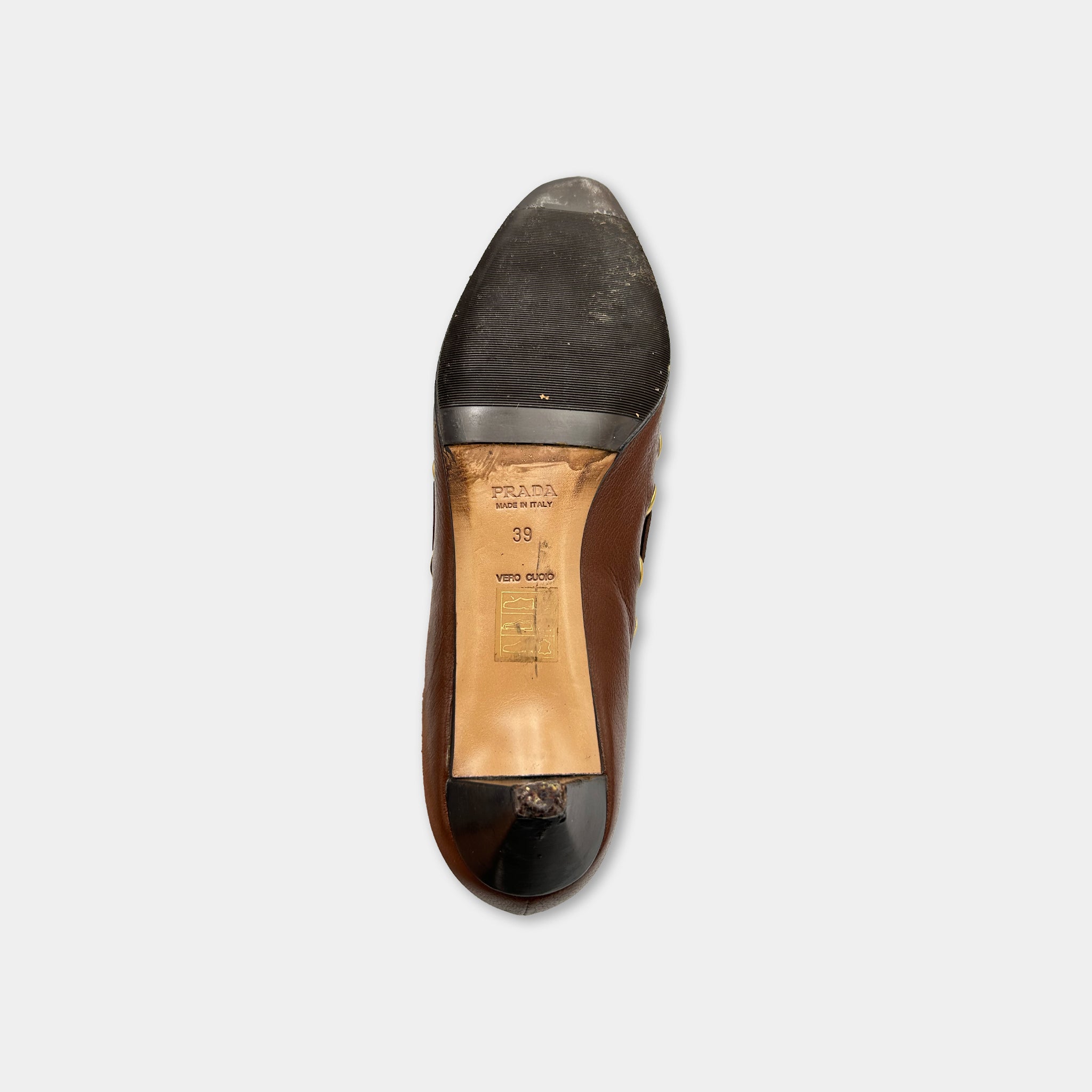 the sole of a brown high-heeled shoe against a white background.