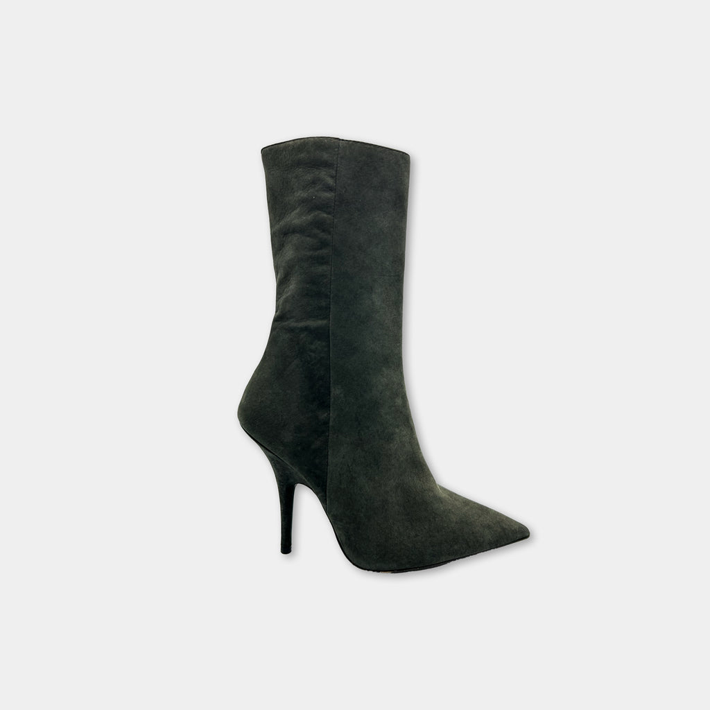 A single, dark green suede ankle boot with a pointed toe and a high heel.