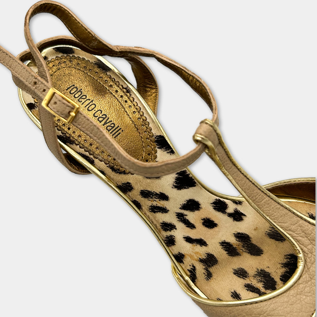 A close-up view of a beige high-heeled shoe with a leopard print pattern on the sole.