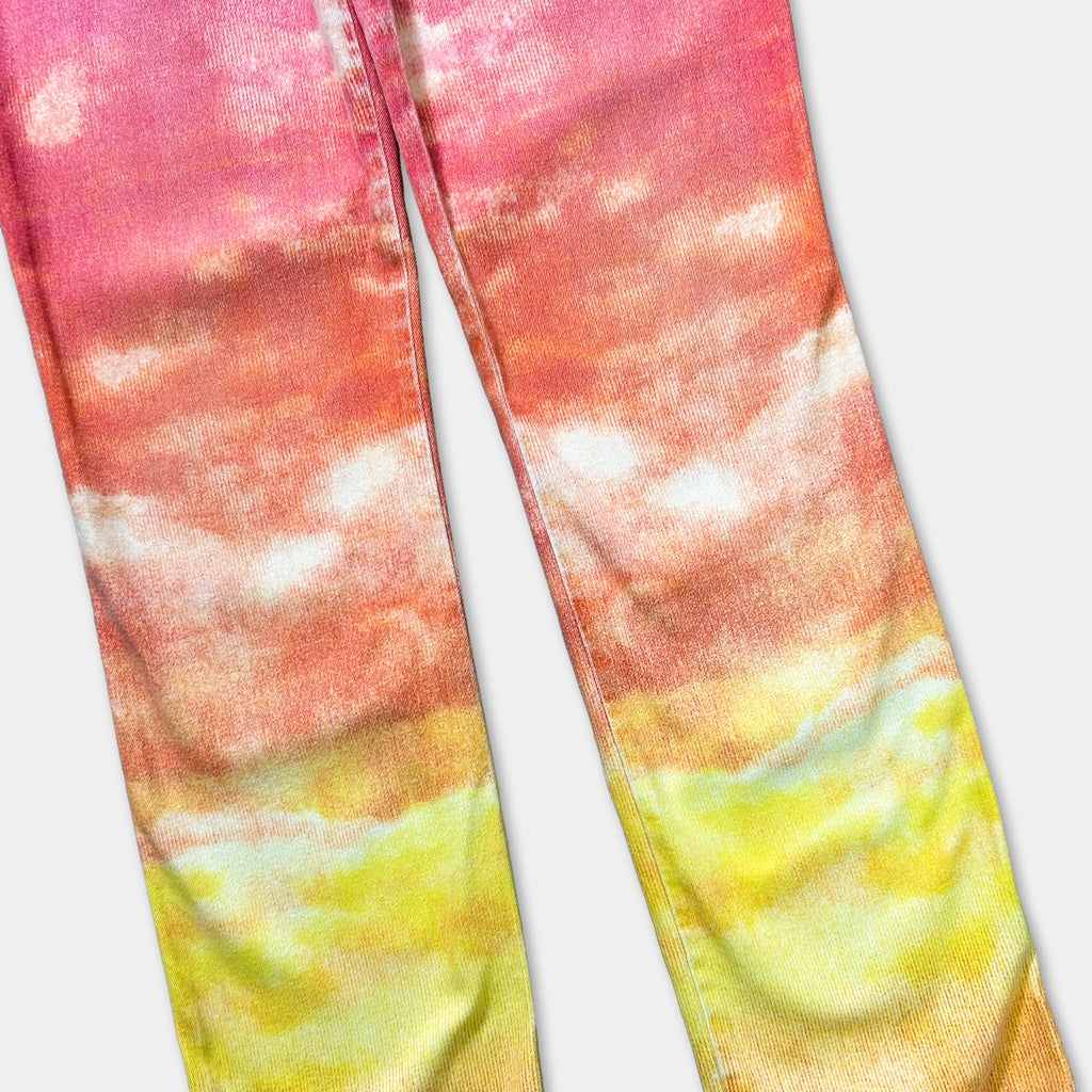 A pair of colorful pants with a vibrant cloud-like pattern in shades of pink, orange, and yellow.