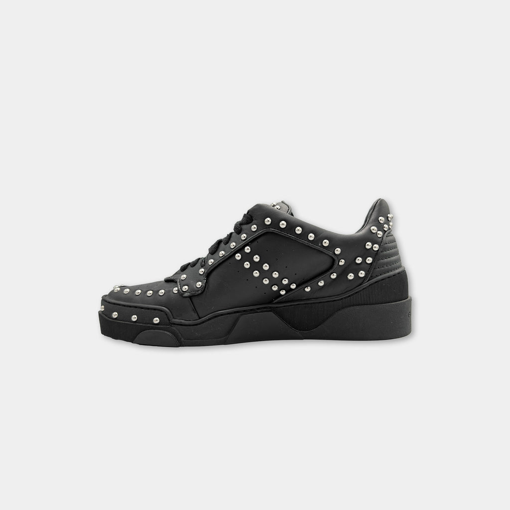 A black and silver sneaker with a studded design.