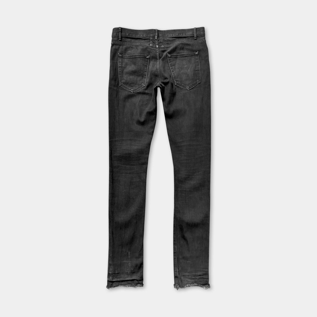 A pair of black skinny jeans with a frayed hem.