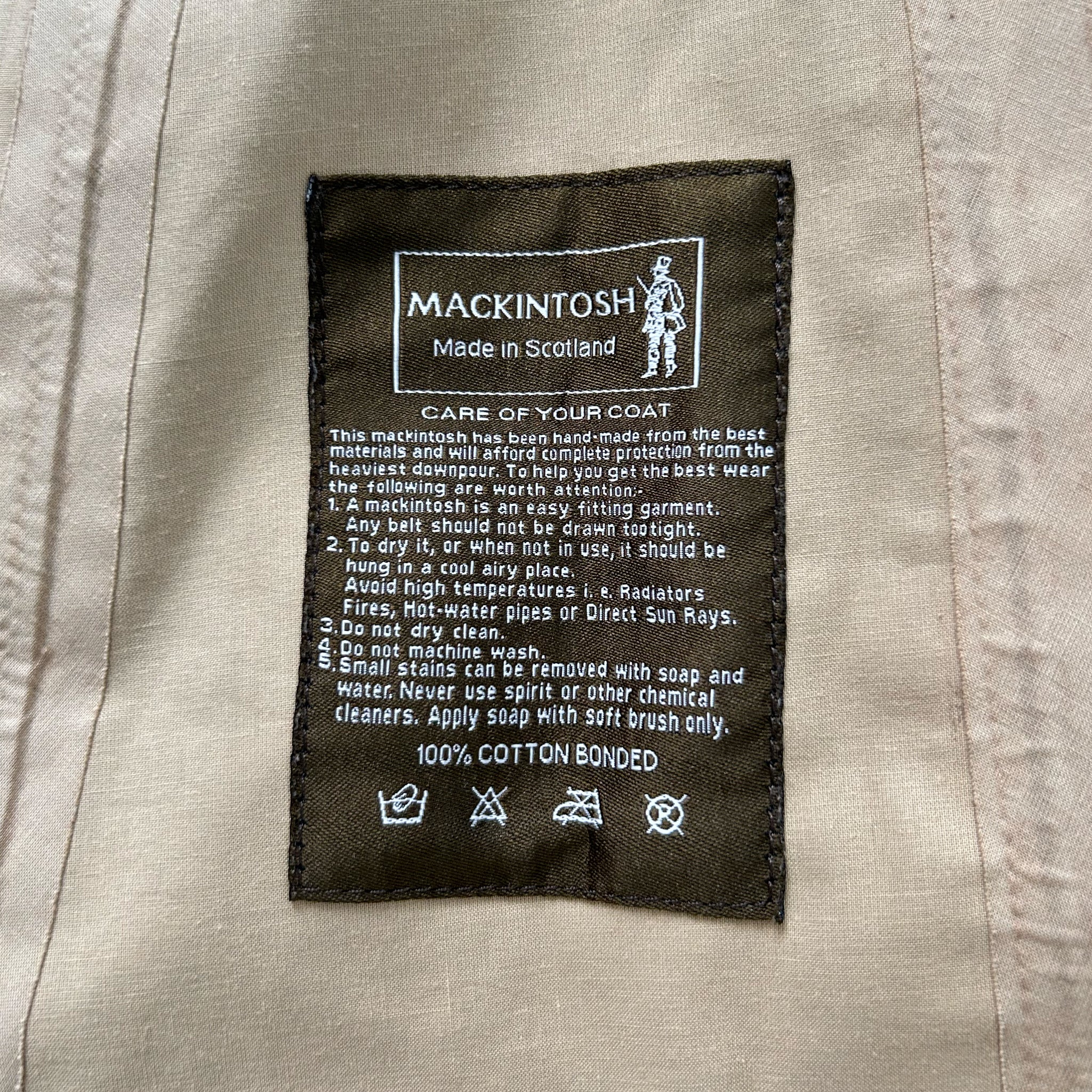 a close-up of a label on a piece of clothing, likely a coat, with text and symbols providing information about the product.