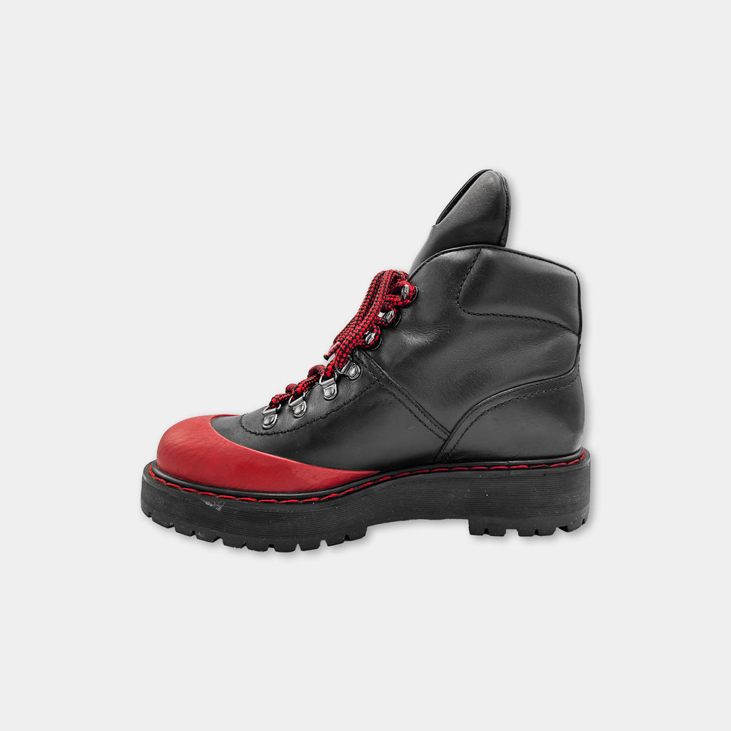 A black and red hiking boot with a red lace and a red sole, designed for outdoor activities.