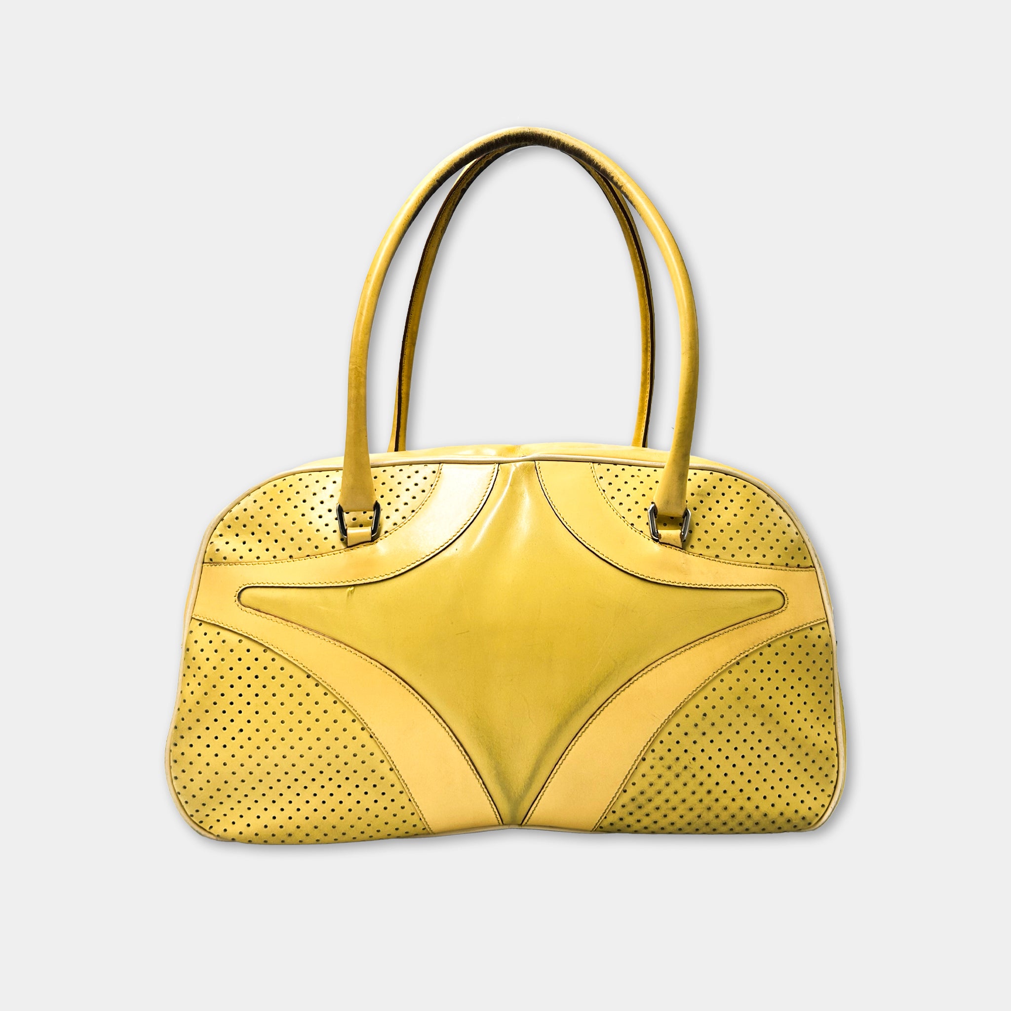 A yellow handbag with perforated details and two handles.