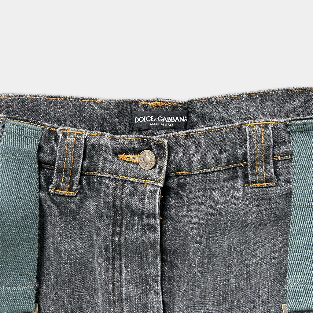 A close-up view of a pair of black denim jeans with a label on the waistband.
