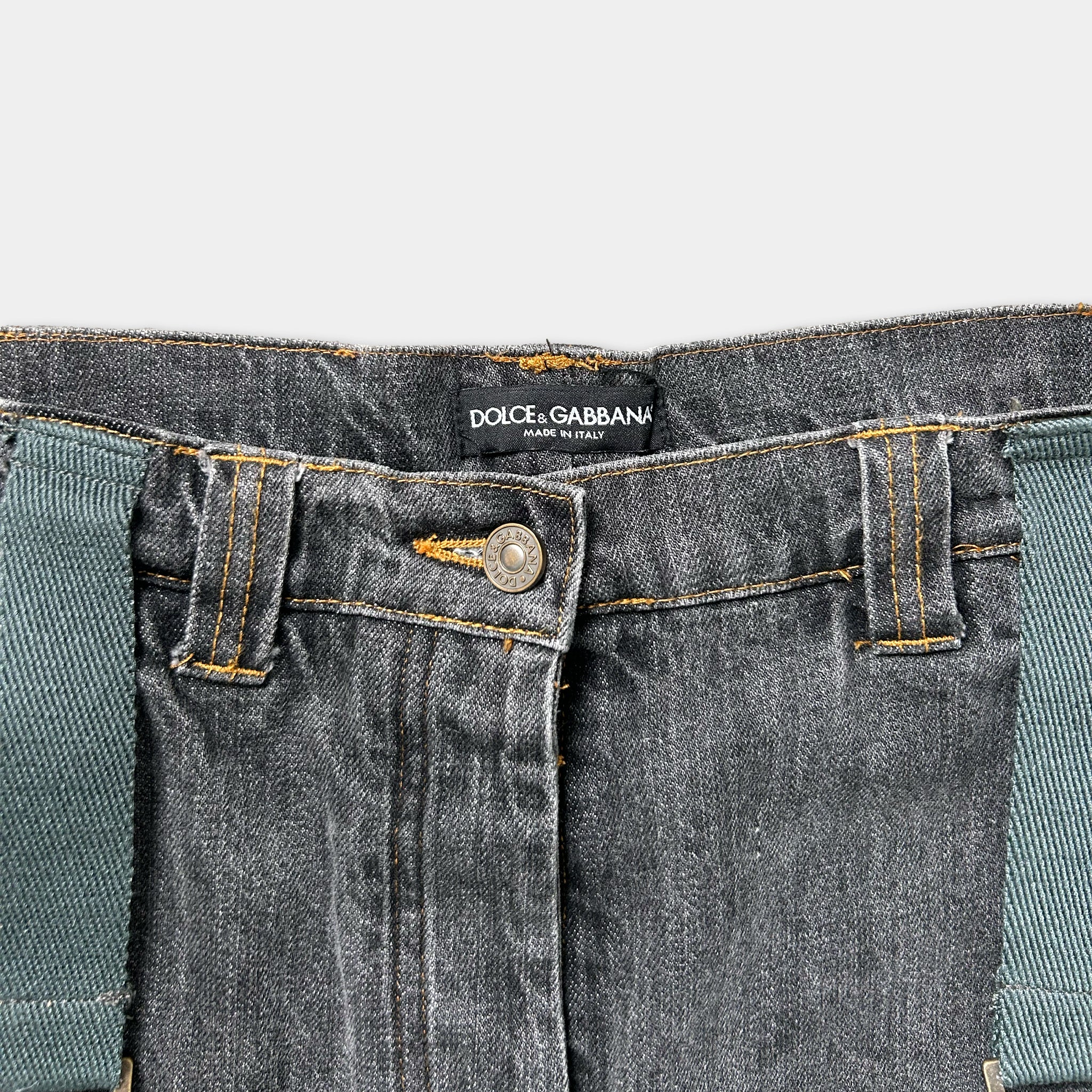 A close-up view of a pair of black denim jeans with a label on the waistband.