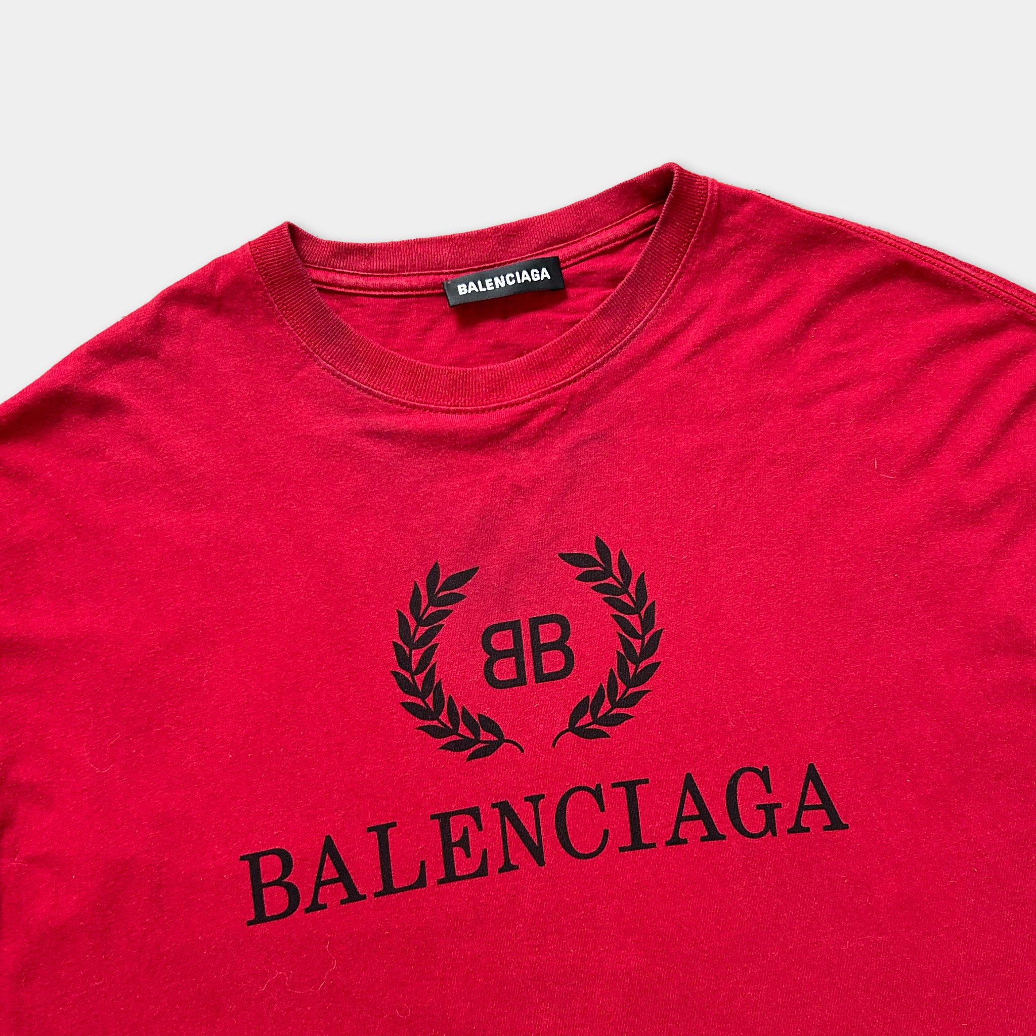 A red Balenciaga t-shirt with the Balenciaga logo and the text "Balenciaga" printed on it.